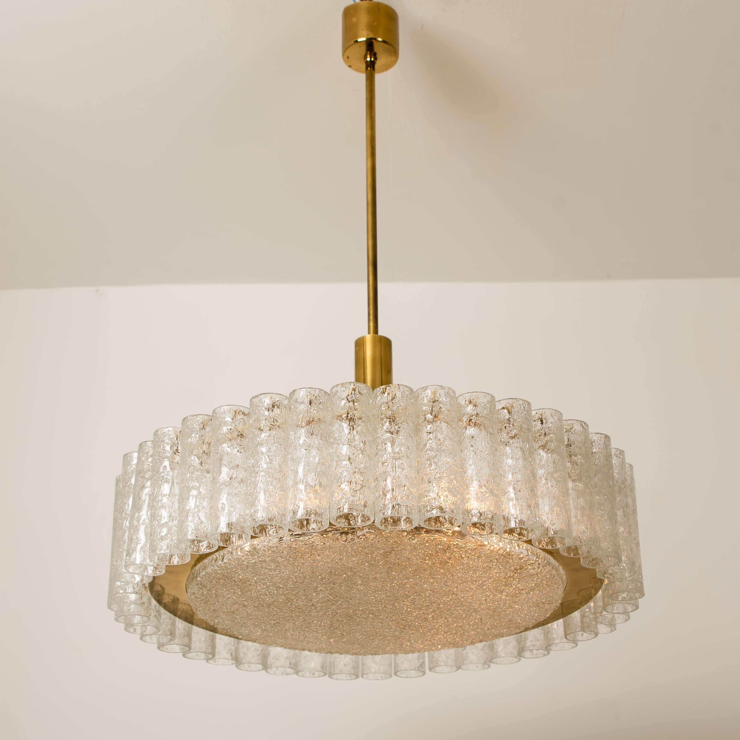 Wonderful pair of light fixtures by Doria (Germany) manufactured in the 1960s-1970s.

Hanging cylinders of textured organic glass tubes separated by brass details. For a clean and elegant look. The glass dishes of the chandeliers are made of