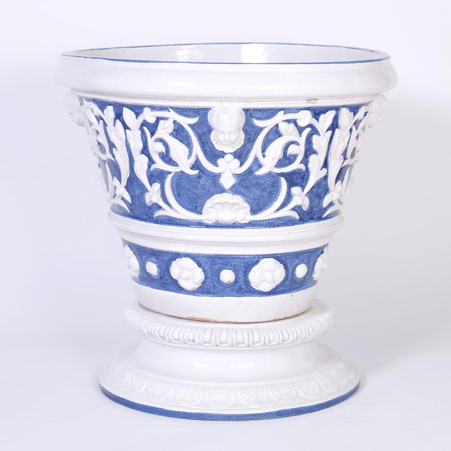 Pair of terra cotta planters with old world style and charm, decorated with classical floral motifs in blue and white under glaze.