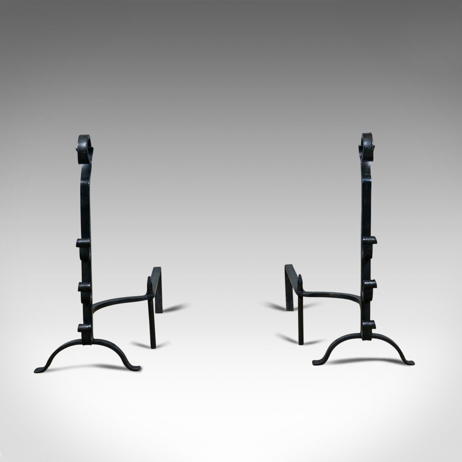 This is a pair of large, gothic, wrought iron firedogs, medieval revival andirons forged in the 20th century.

Bold andirons ideal for a large fire basket
Standing upon a forward arch leg and a pair of basket legs
Medieval revival in