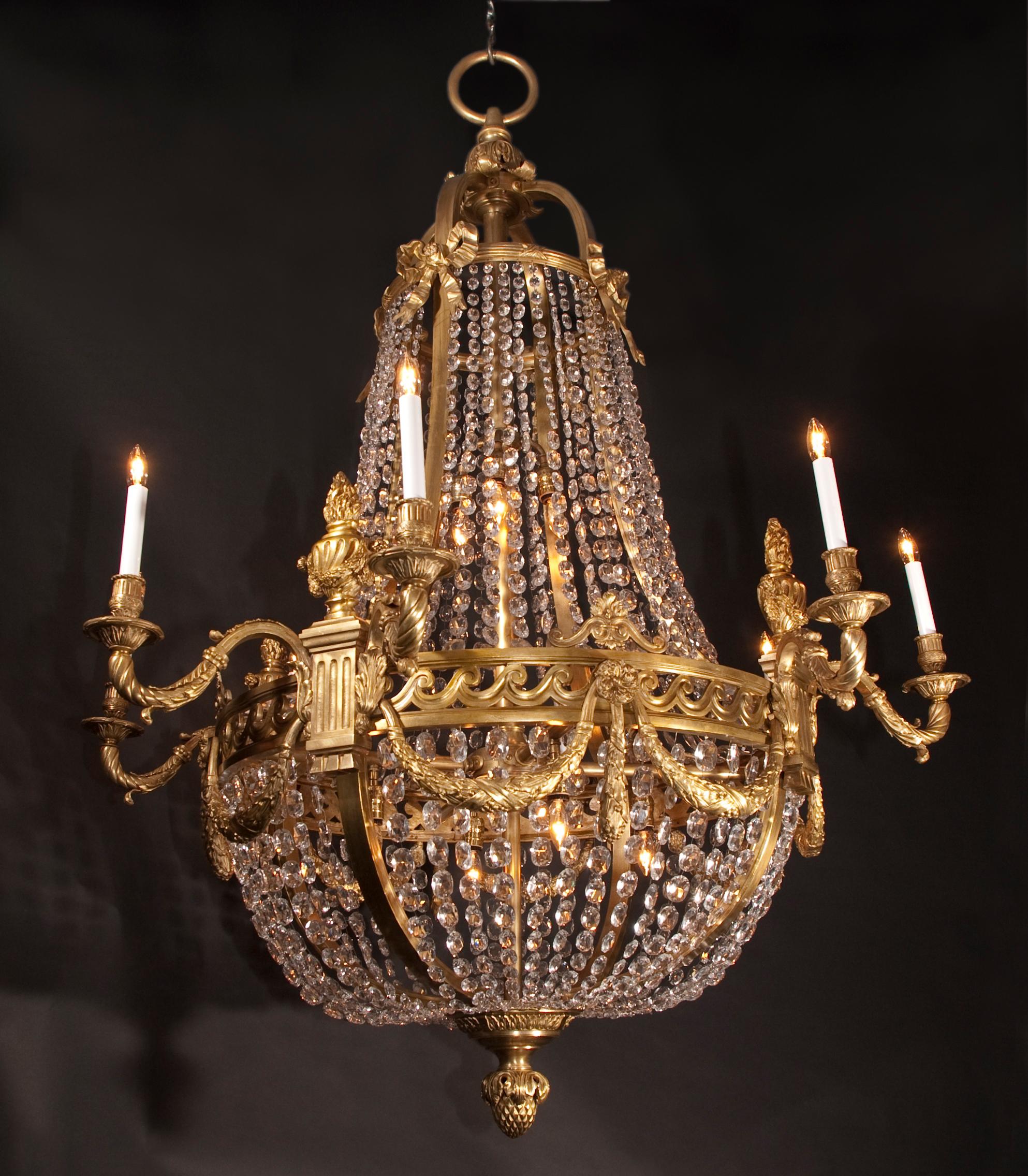 Ces magnifiques lustres Grand Louis XVI sont en bronze et drapés de rangées de cristaux octogonaux. La paire d'antiquités françaises date du XIXe siècle et offre une multitude de détails. La couronne est un groupe de feuilles d'acanthe, tombant en