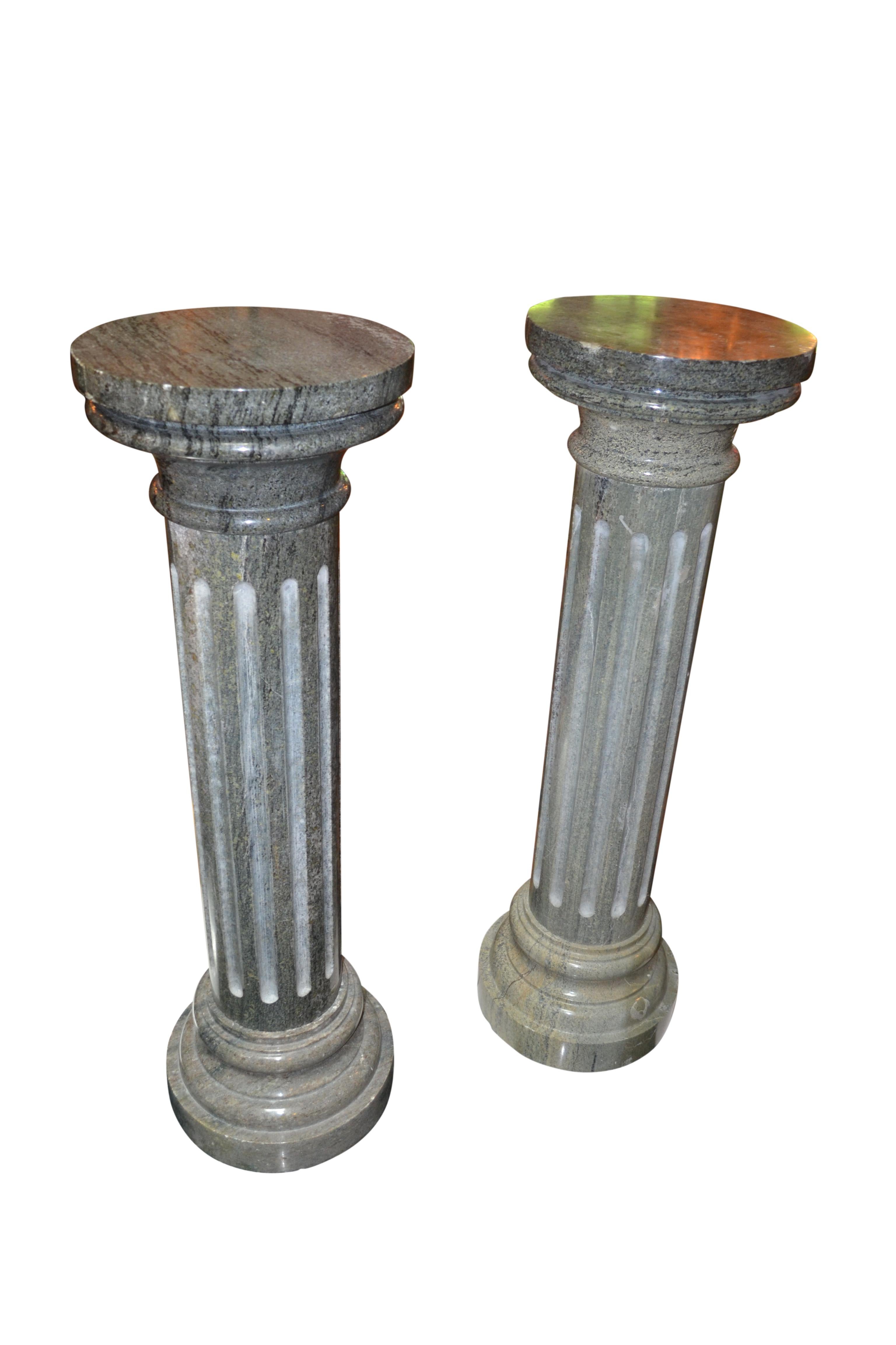 A pair of fluted round marble columns, the marble being a mid green colour with grey veining; both with circular tops and bottoms; likely Italian late 19thC. 
