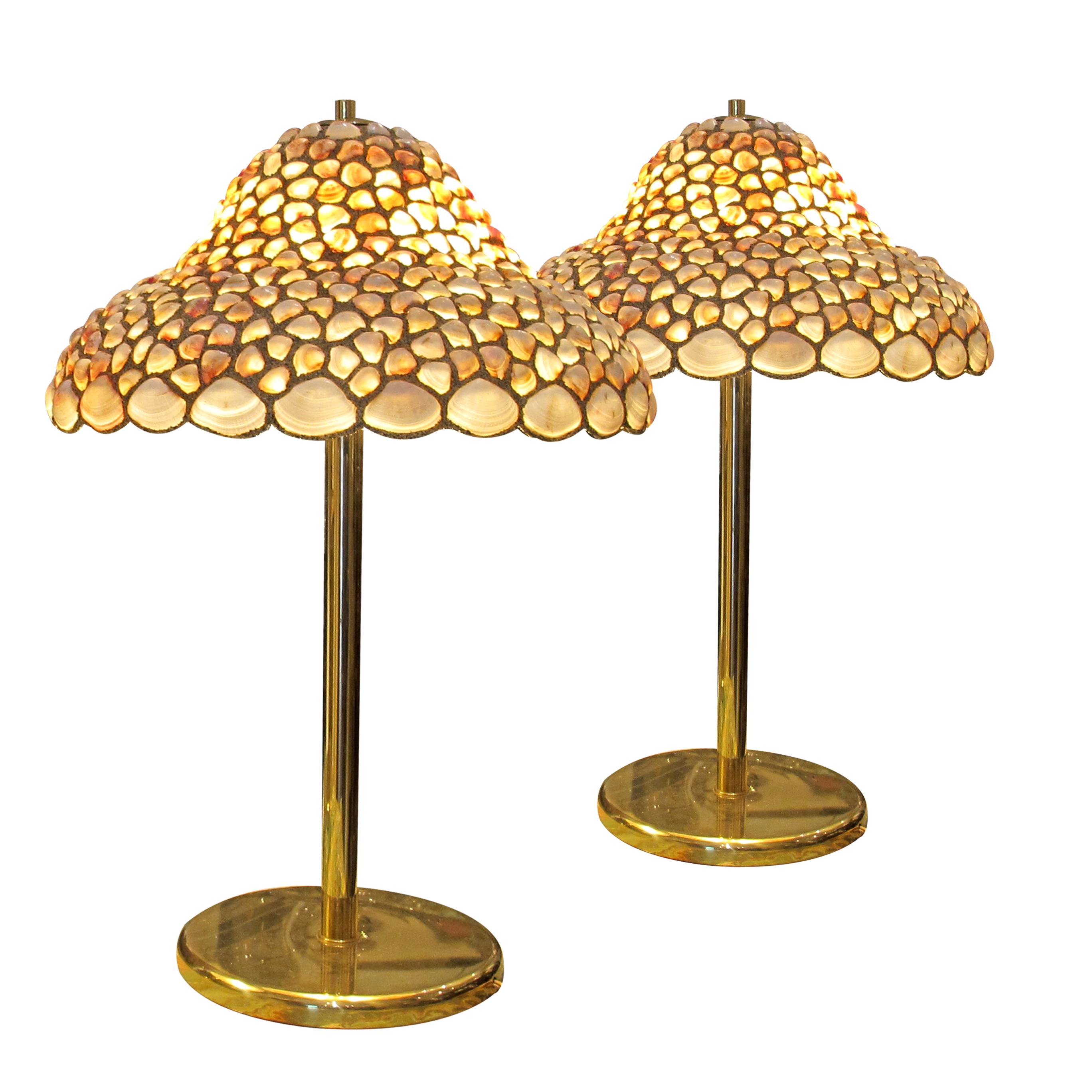 This stunning pair of large table lamps from the 1970s is handcrafted. Each lamp features a beautifully contoured shade meticulously assembled from natural seashells, set in fine sand, creating a textured, organic look. The shells are arranged in a