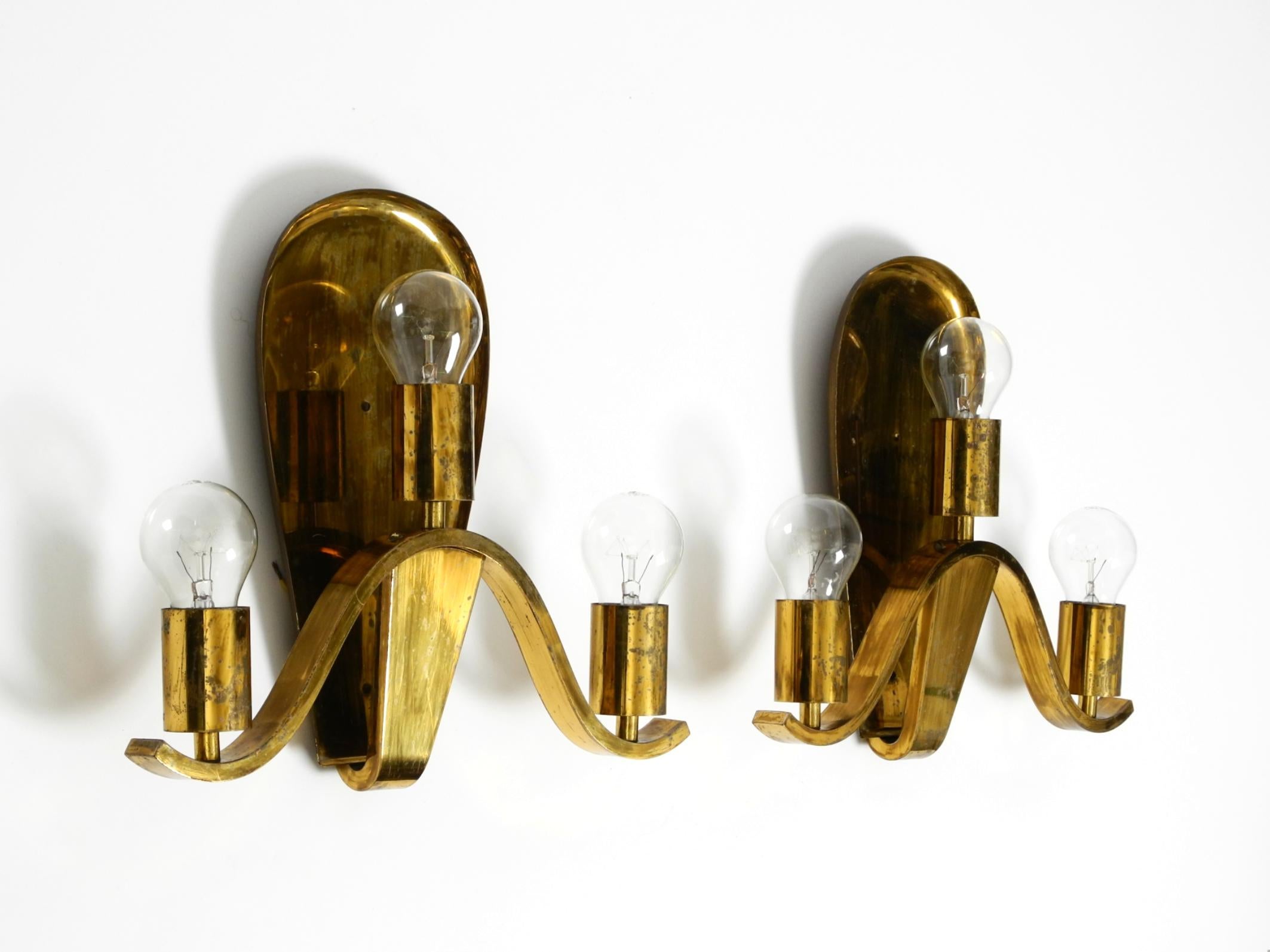 Two very rare, elegant, large mid-century modern brass wall lamps
made of solid, shiny brass. Great patina on the brass.
Hung for decades in a German church in northern Germany.
Fully functional with three original E27 sockets for up to 100W