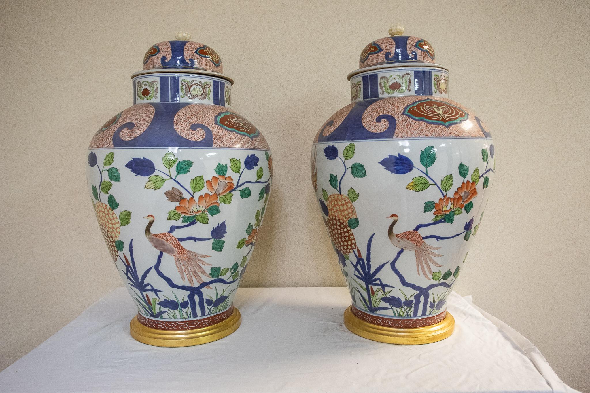 Pair of large 19 century Japanese Imari floral motif covered vases in the shape of ginger jars.
Mounted on giltwood bases.