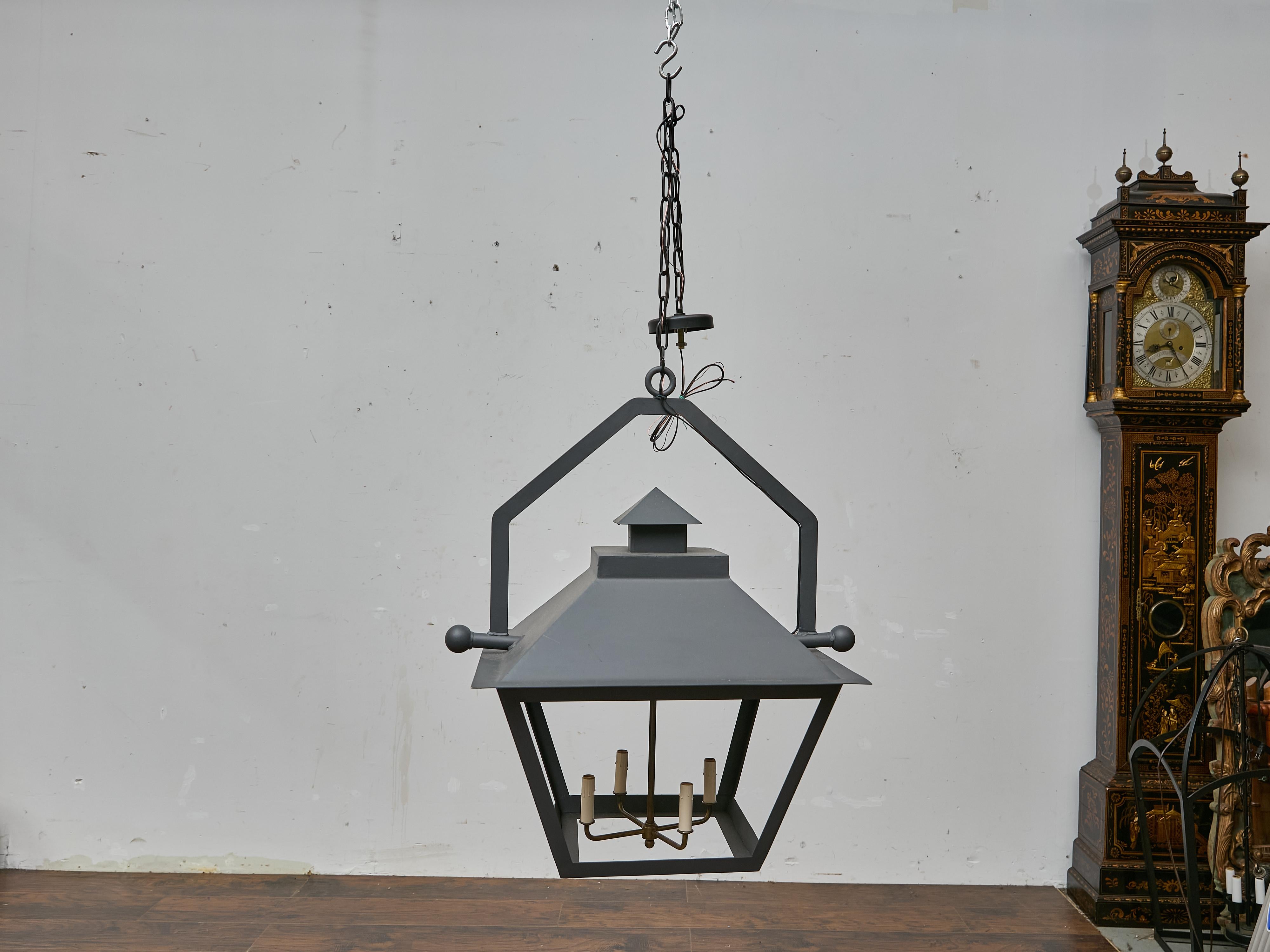 A striking pair of large-scale iron lanterns, newly made and designed with clean, architectural lines. Each lantern features a bold geometric frame with a peaked roof, creating a strong silhouette that blends historical reference with contemporary