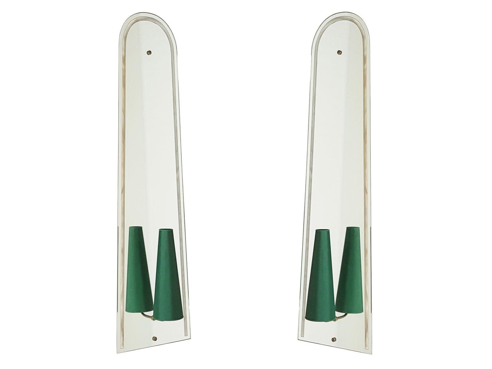 This pair of huge wall lights was produced in Italy, circa 1950s. A solid wooden frame supports the shaped mirrored glass with a clear glass decoration frame. At the bottom, a thin brass arm support the light bulb holder and its related green fabric