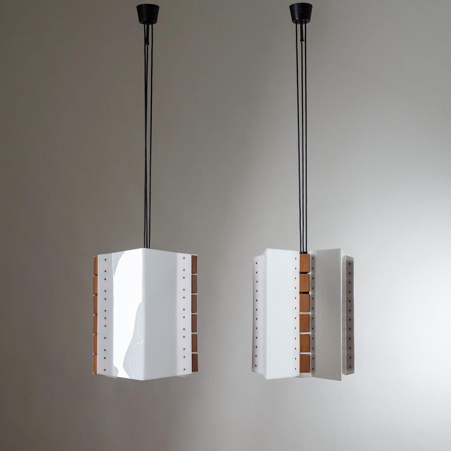 Rare pair of large Italian pendants from the 1960s. The body is composed of three triangular-shaped acrylic sheets joined together by teak blocks and suspended by the wires which lead to three E27 sockets. Very good original condition with minimal