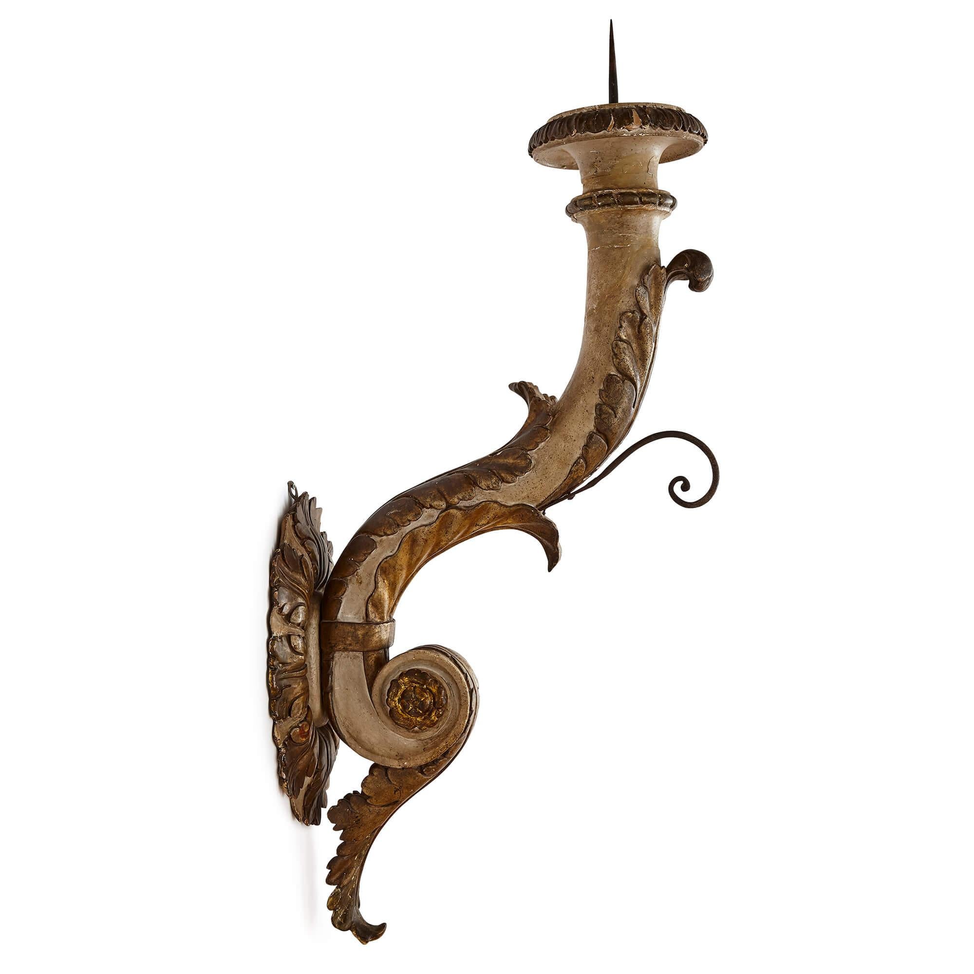 Pair of large Italian Baroque style carved giltwood sconces
Italian, early 20th Century
Height 92cm, width 26cm, depth 48cm

This elegant pair of sconces is crafted from carved wood that has been painted and gilt. The sconces are in the Baroque