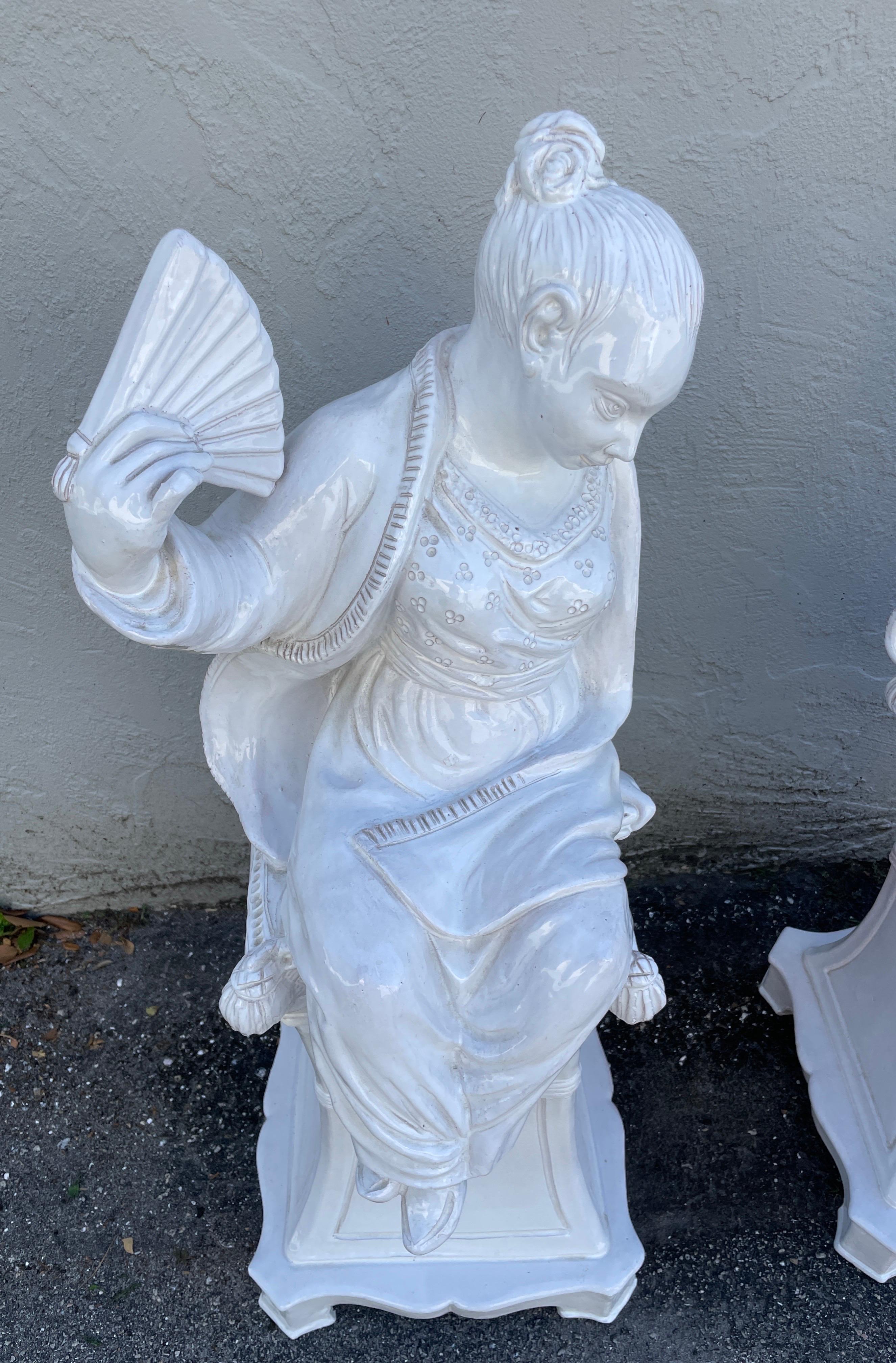 Maravillosa pareja de figuras masculinas y femeninas de terracota blanca esmaltada a gran escala, sentadas sobre pedestales a juego. Se fabricaron en Italia. Harán las delicias y realzarán cualquier ambiente.