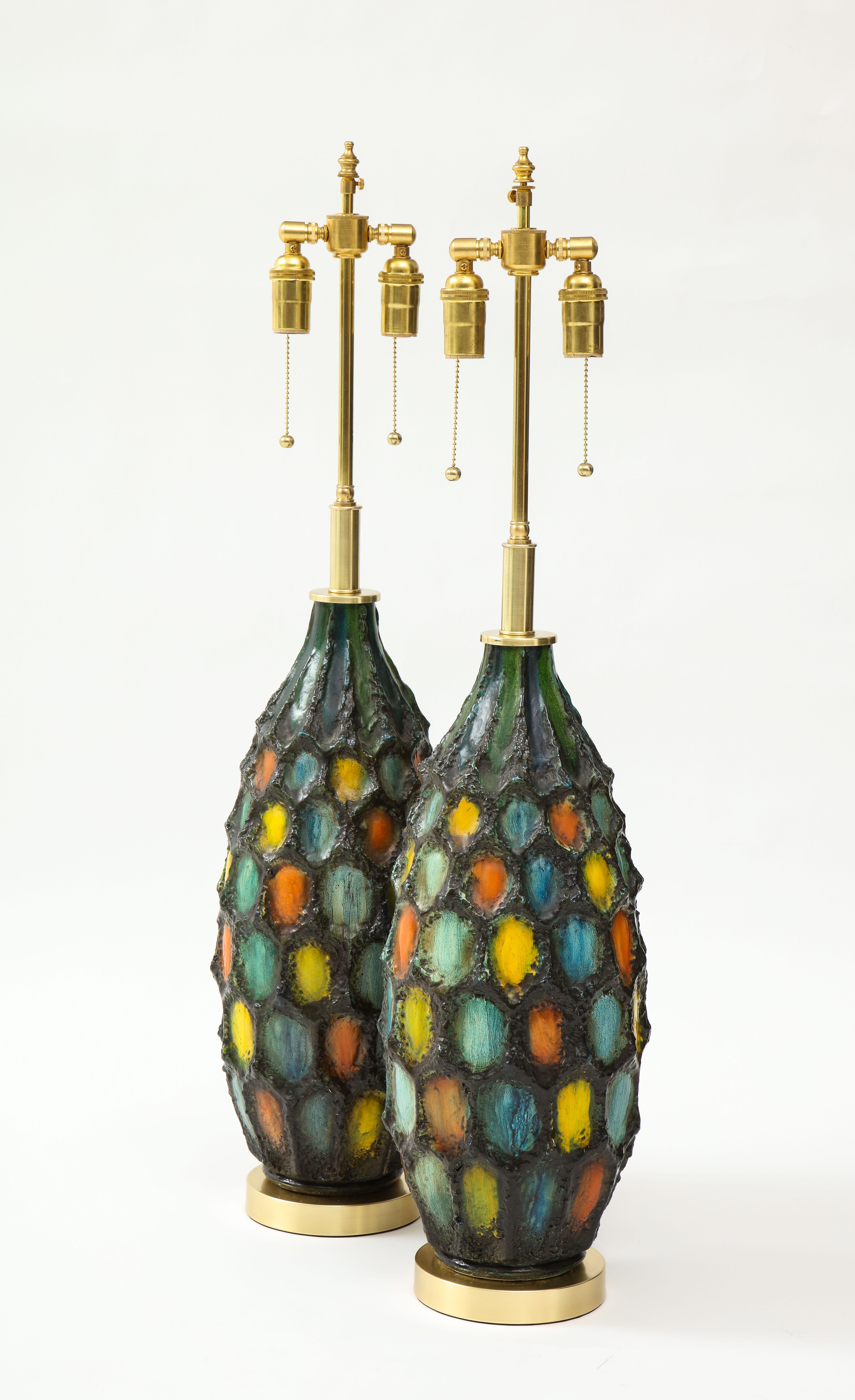 Large pair of Italian ceramic lamps with a textured volcanic glaze.
The lamps are mounted on brass bases and they have been newly rewired
with adjustable polished brass double clusters that take standard size
light bulbs.
The height to the top