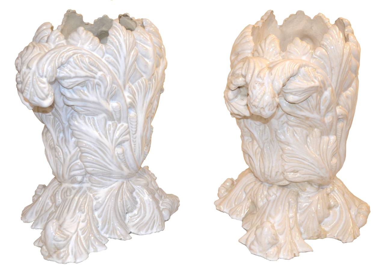 Pair of dramatic and elaborate Italian Faience glazed ceramic planters (or vases) using Renaissance-style Acanthus leaves is sure to make a bold statement in a home or commercial setting such as a hotel lobby or restaurant. One planter is white with