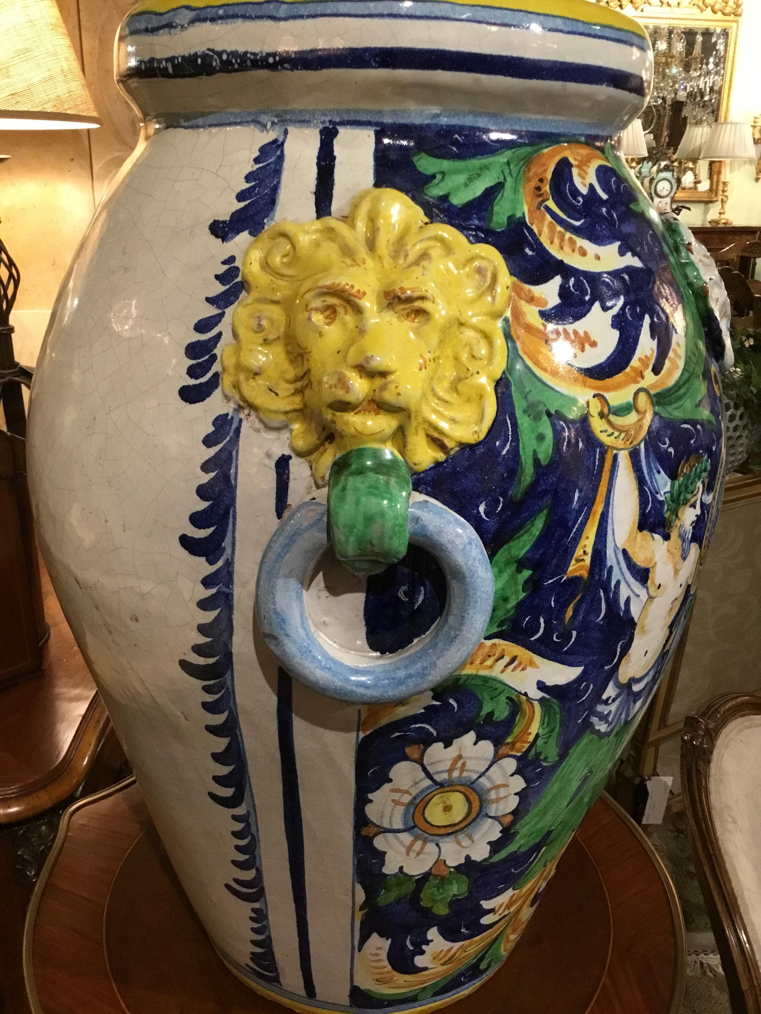 Exceptional pair of Italian vases depicting Baccantes and having
A center crest with a lion and Fleur de Lis, Lion masks with rings
Decorate the sides of these colorful pieces.
Yellow, green and blue hues in vibrant co.







  
