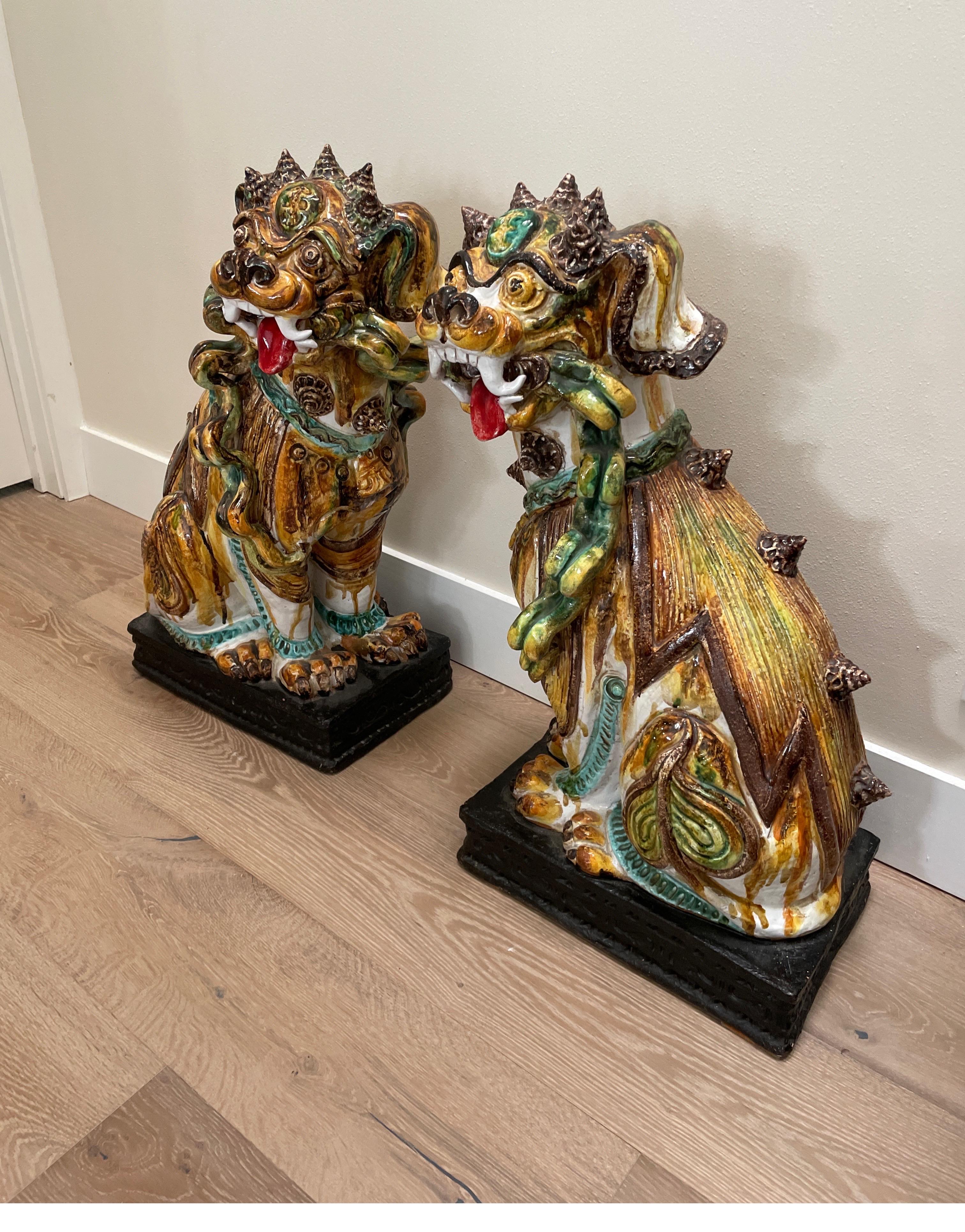 Very unique pair of large multi colored glazed terra cotta foo dogs. These mid-20th century foo dogs are beautifully done and quite rare.