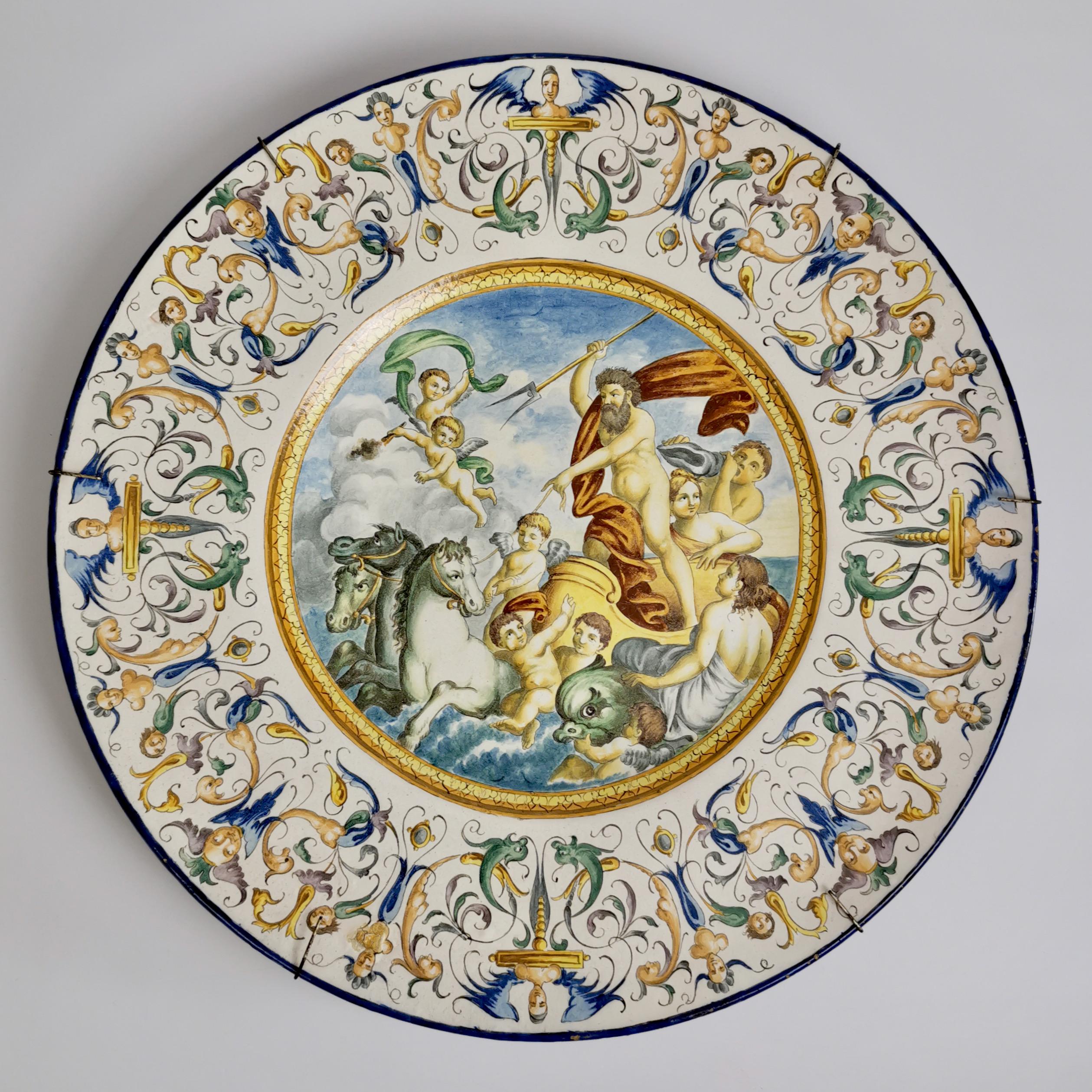 On offer is a wonderful pair of huge Italian maiolica chargers made in the 19th Century. The chargers are painted with lively scenes of Neptune and Venus in carriages drawn by horses and hippocampi. They are surrounded by all manner of putti and