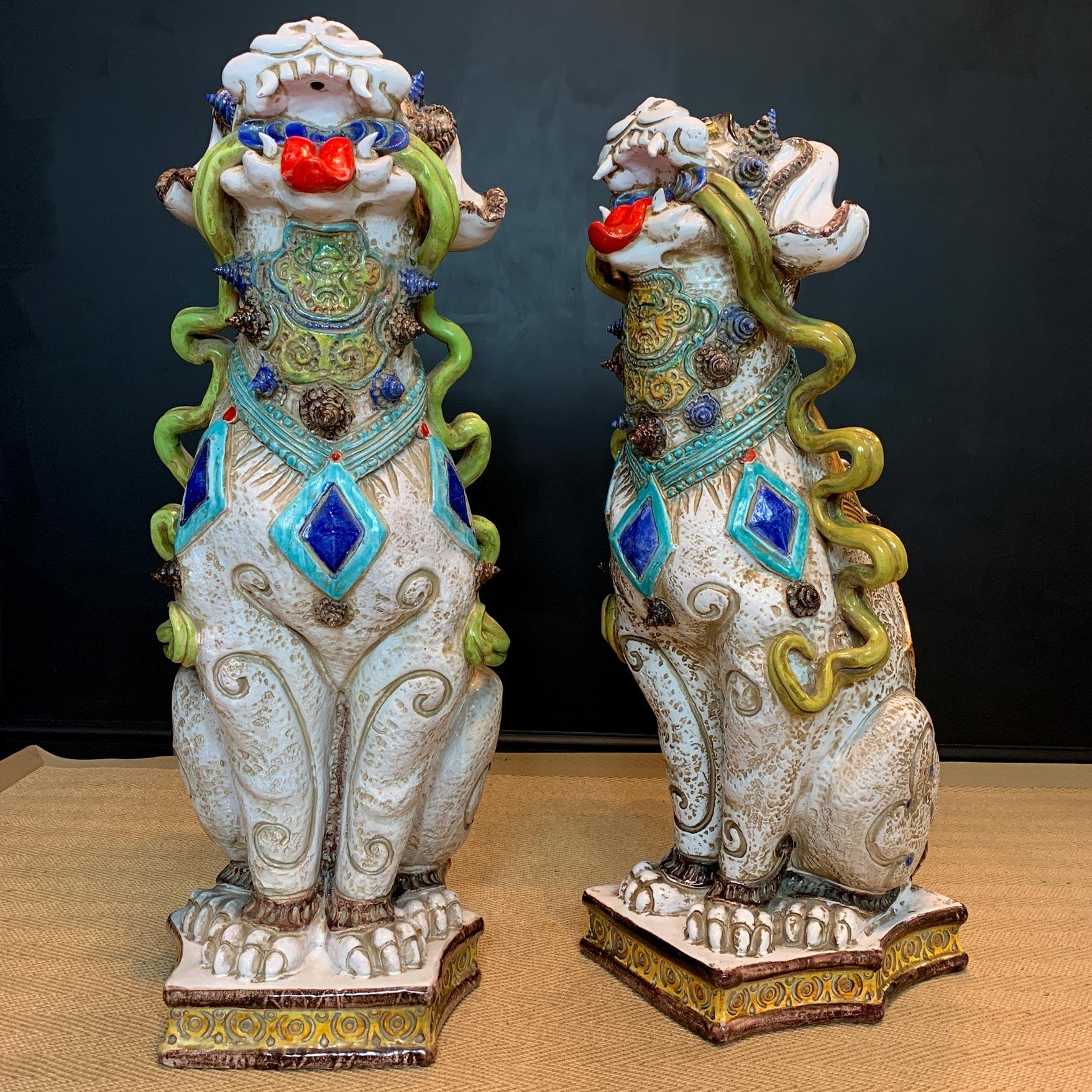 An outstanding pair of glazed terracotta Italian Majolica Foo Dogs.

Dating to the 1950's and earlier, Italy.

This incredible pair of lifesize Foo or Temple Dogs each superbly hand crafted and glazed. The profuse decoration including ribbons,