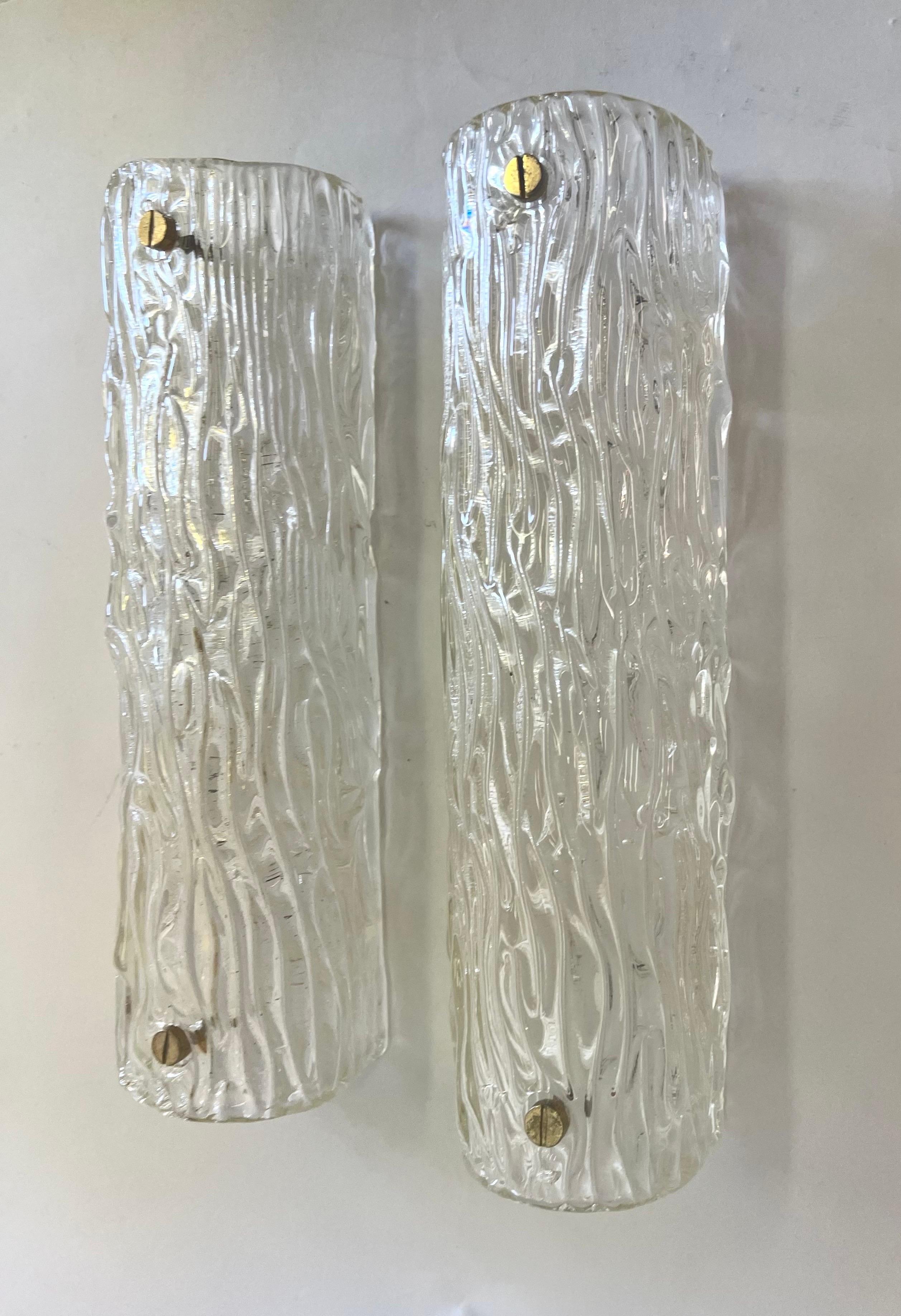 A Pair of Large, Italian Mid-Century Modern Murano / Venetian glass wall lights or sconces in a thick, opaque clear glass; and composed in an abstracted tree bark pattern, known as 