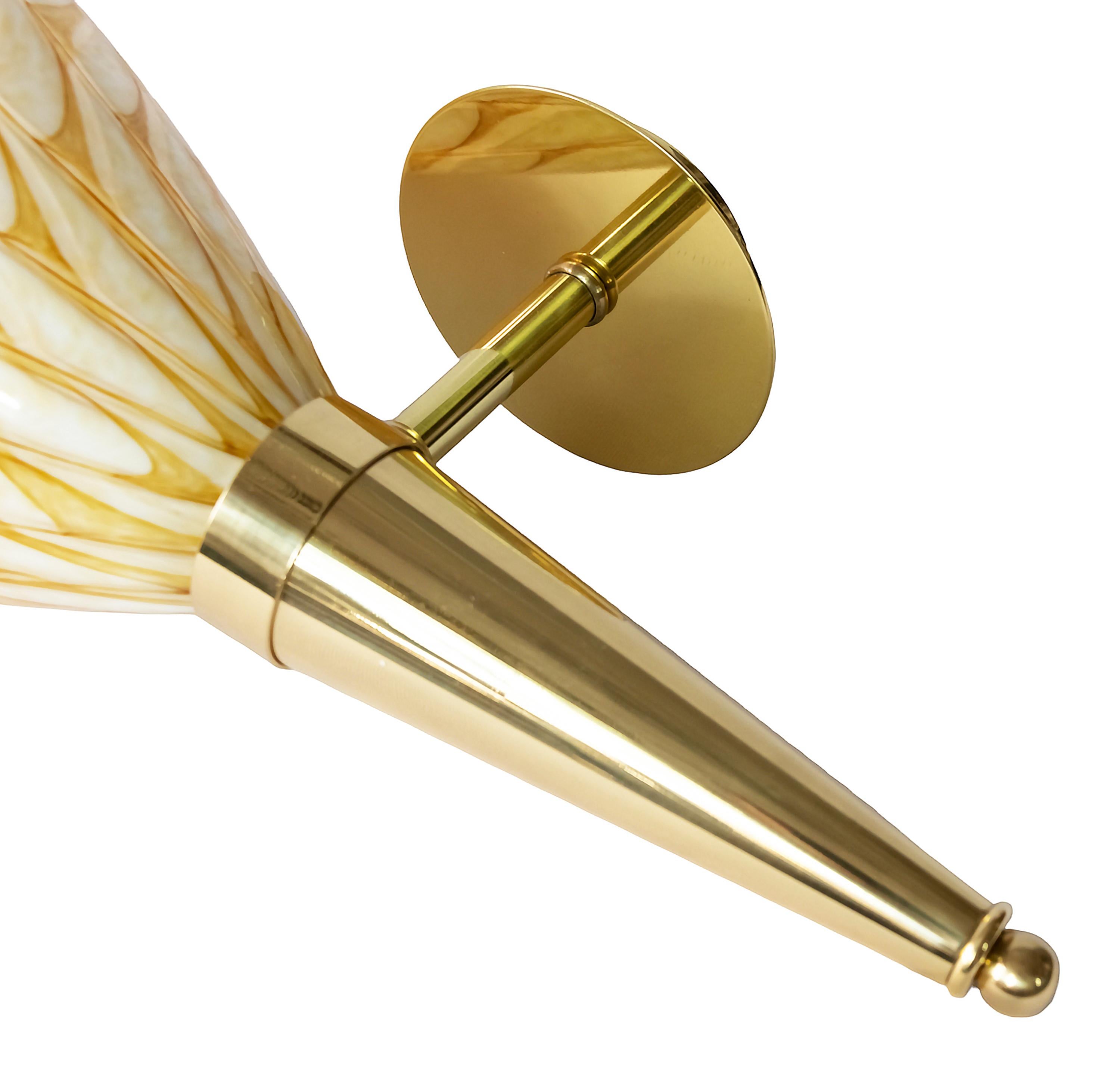 Coppia di applique realizzate con supporto in ottone e vetro di Murano lavorato a mano. 
Il vetro è di colore beige/giallo tenue con un motivo marrone all'esterno e bianco all'interno.
Portalampada: Tipo E27, 1 pezzo per ogni applique (le lampadine