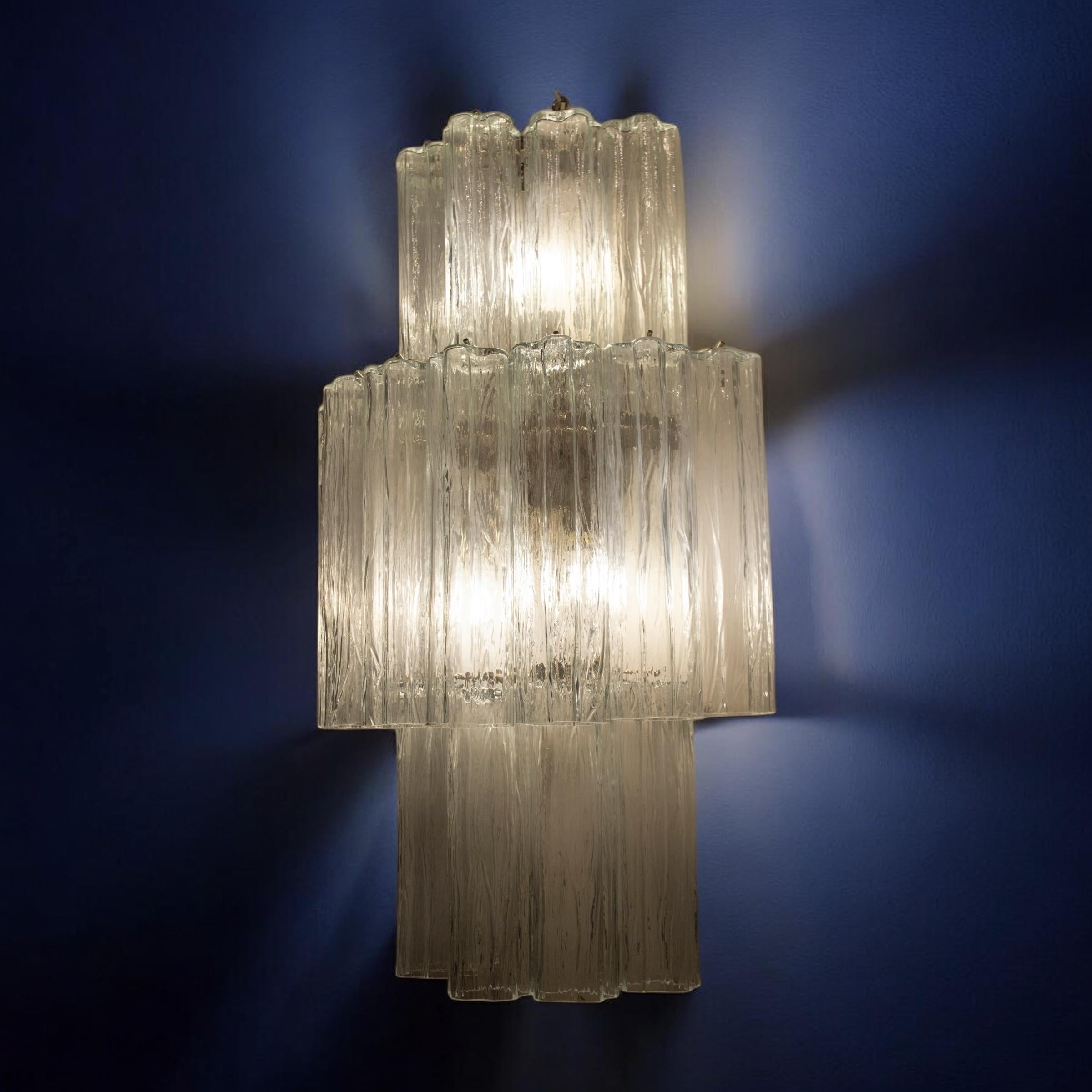 Pair of monumental wall lights composed by dozens of precious 'Tronchi' Murano glasses on tree levels with clear color glasses.
Available 2 pairs of sconces and a  chandelier .
This light fixture can be disassembled and the glasses individually