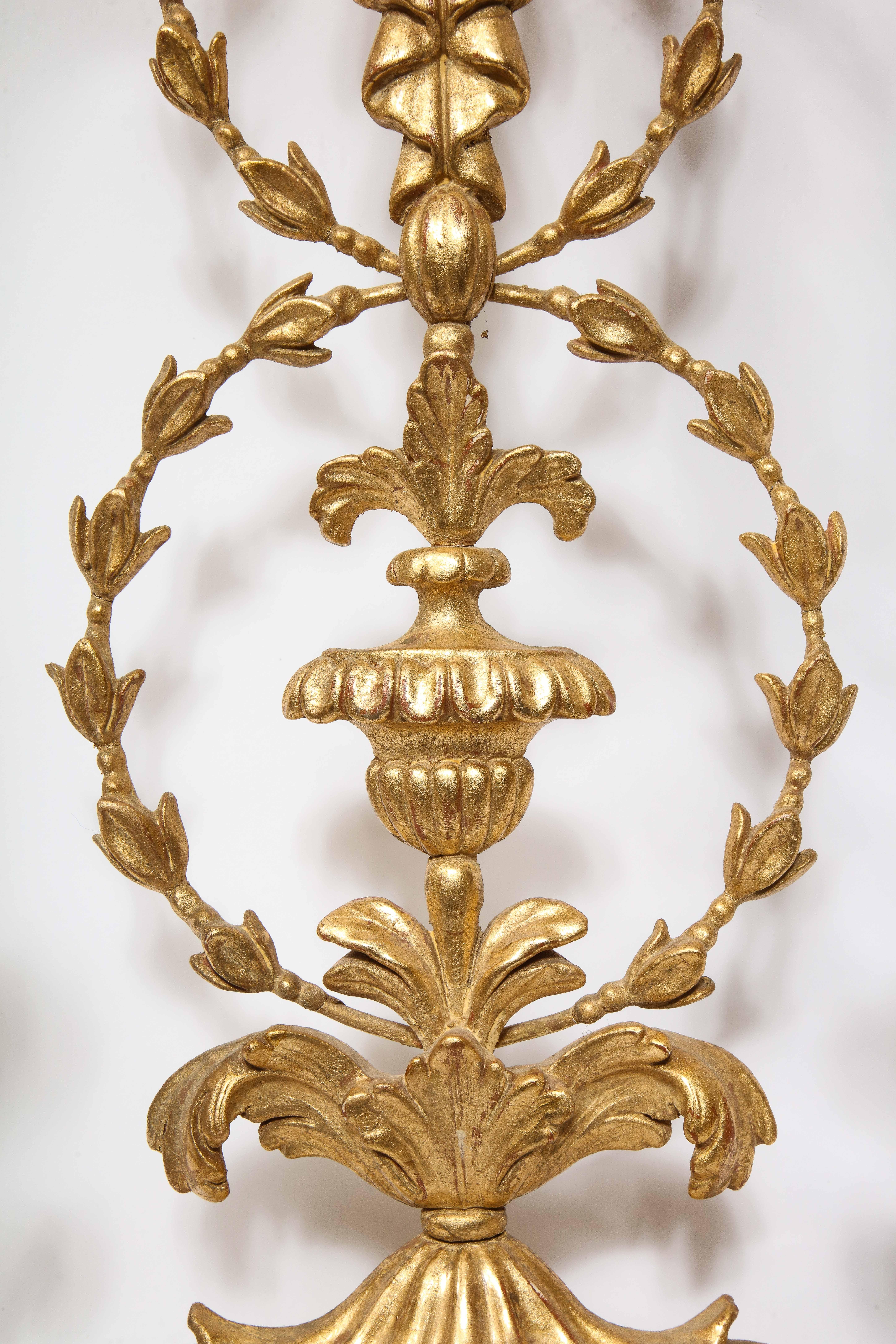 Pareja de grandes apliques neoclásicos italianos de madera dorada tallada de dos luces siglo XX en venta