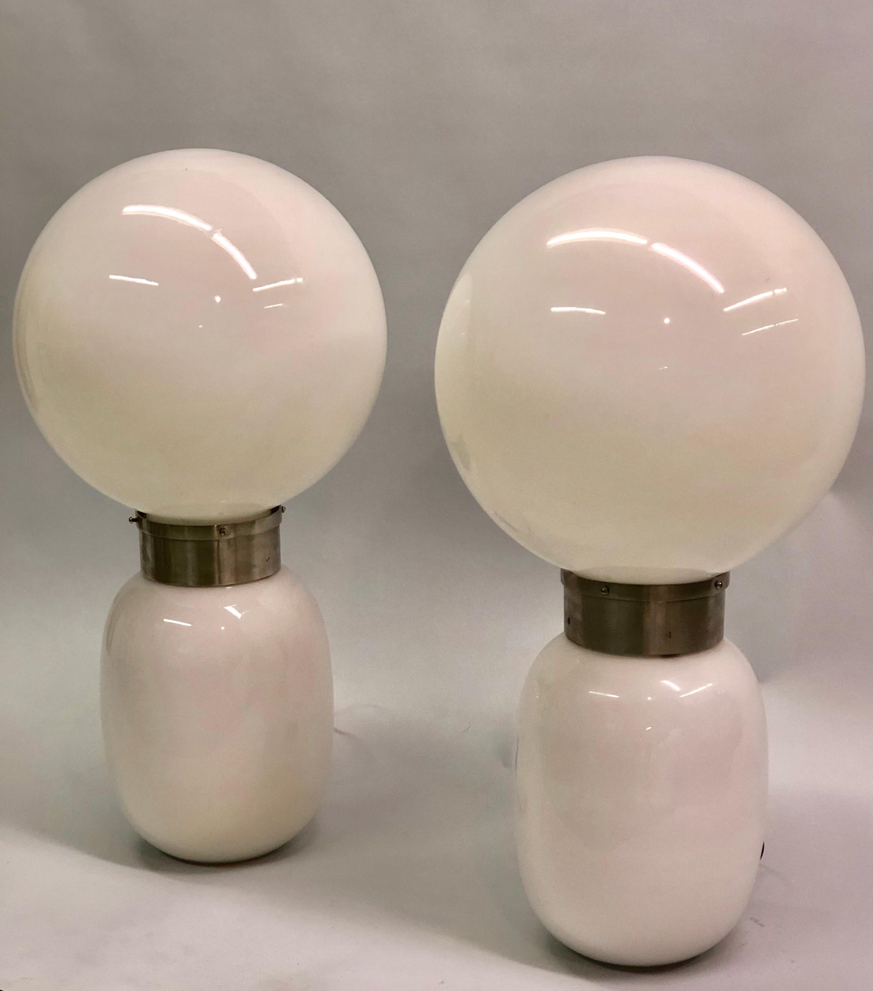 Rare pair of Italian Mid-Century Modern mold blown white Murano milk glass table lamps by Carlo Nason.

The lamps are space age in concept and design and function both practically and as light sculptures with both lower and upper levels illuminating