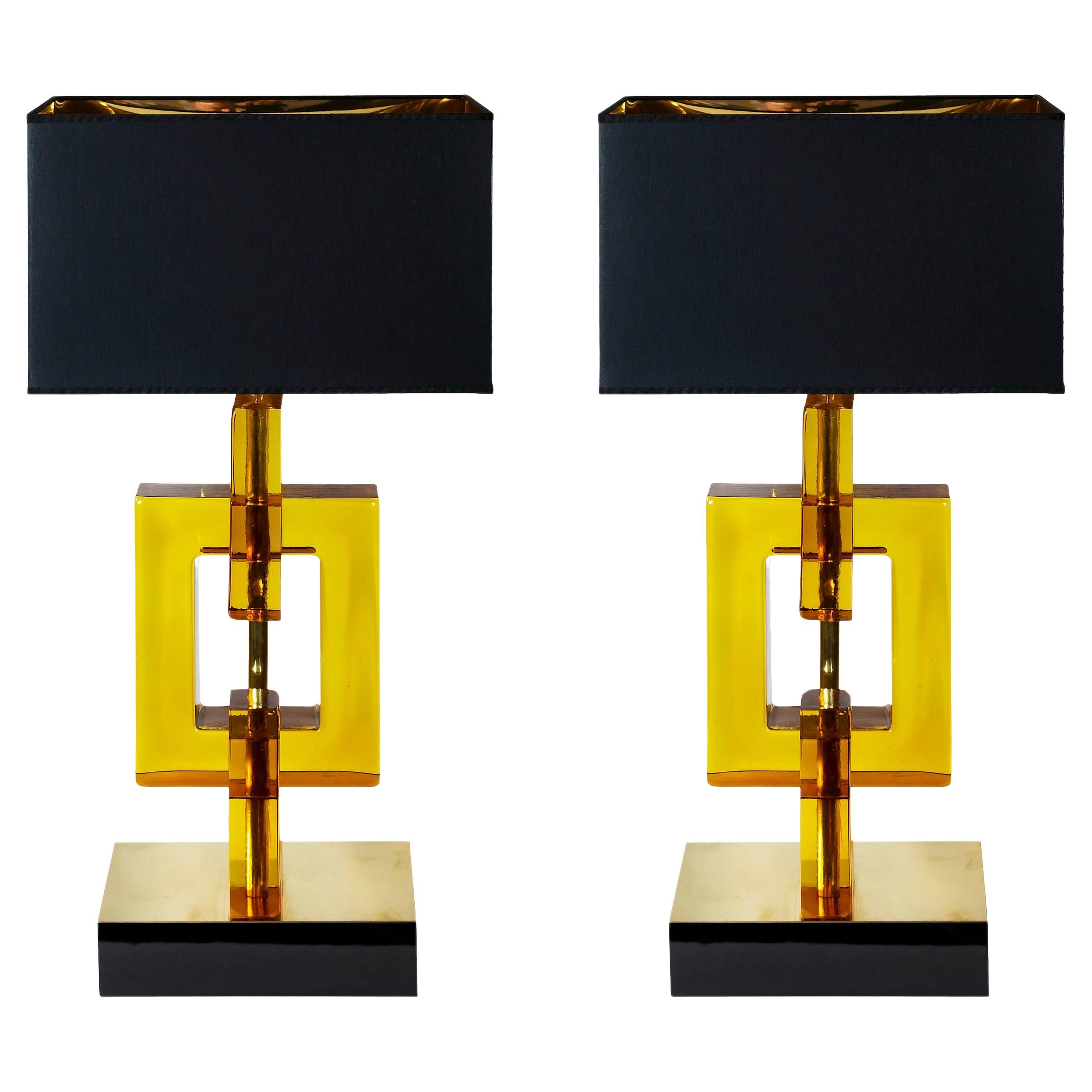 Pair of large Art Deco style Italian table lamps.
The base is made of thick plywood painted in glossy black and decorated with polished brass sheet on the top. The glass part is handmade ambra/amber Murano glass.
Both lamps are with new made satin