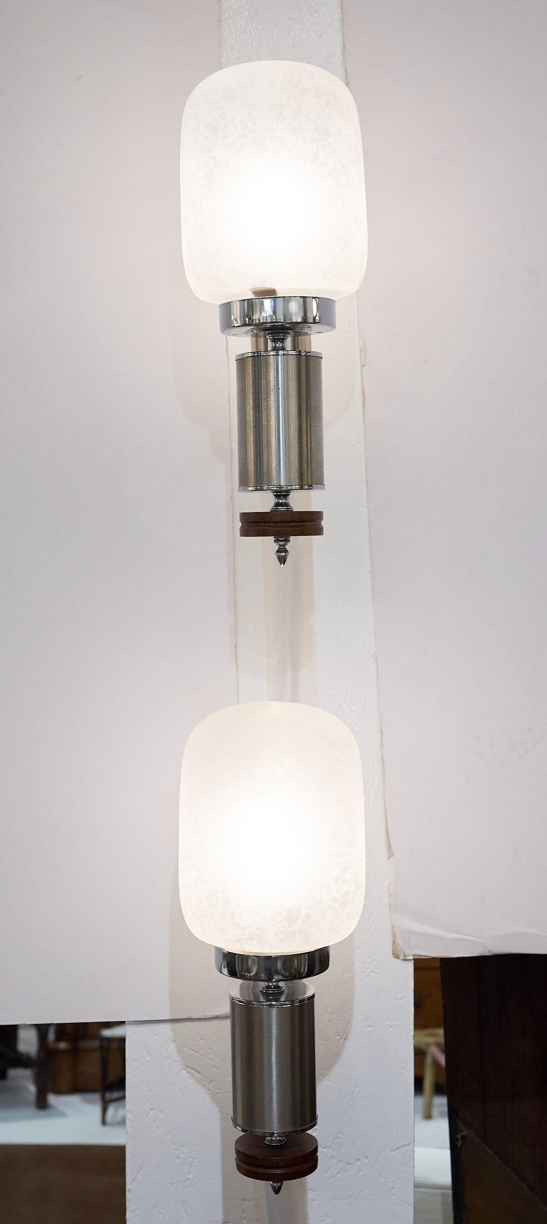 Great pair of oversized Italian sconces made in the 1970s and designed in the style of Mid-Century Modern. A large frosted glass capsule shade rests on a chrome cylinder with a turned walnut accent and chrome finial at its base. The light is held by