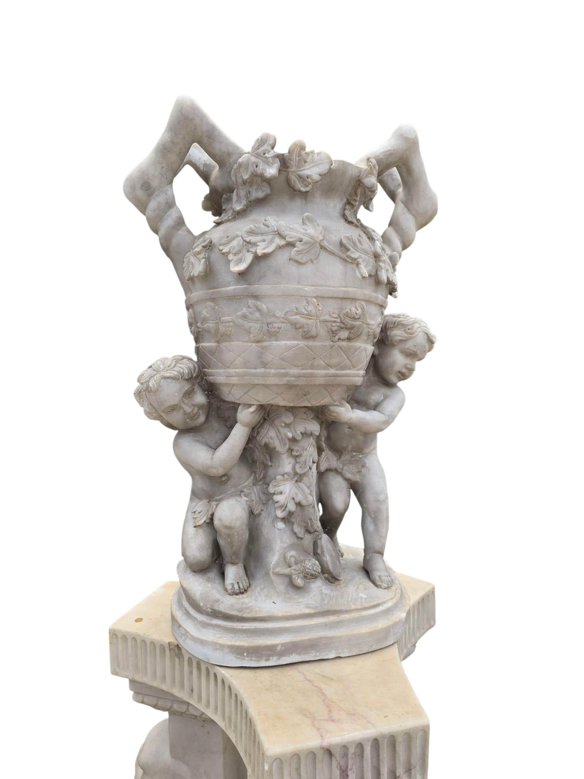 Impressive pair of large urns carved from fine Italian white marble, each adorned with intricately sculpted cherub figures in high relief. The angelic motifs and classical proportions give these urns a refined and elegant presence, ideal for