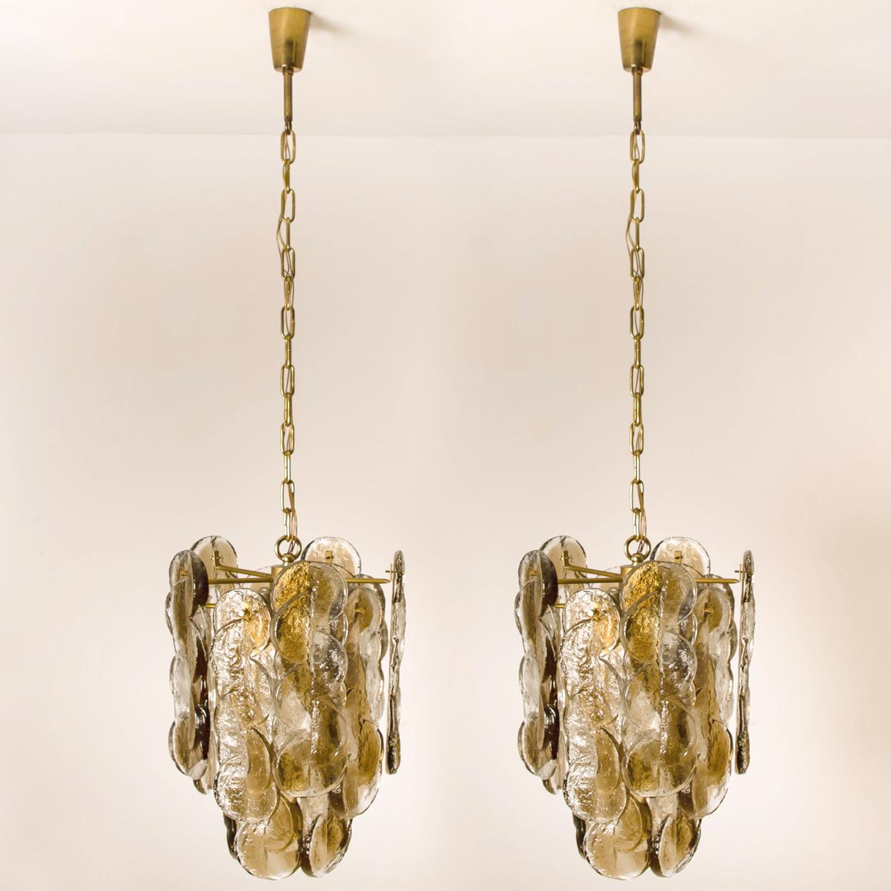 Pair of high quality murano glass chandeliers by Kalmar, 1960s smoked swirl ice glass, clear twisted crystal glass panels with a light gold dish amber colored stripe in it.

Kalmar was the most important producer of premium-quality chandeliers in