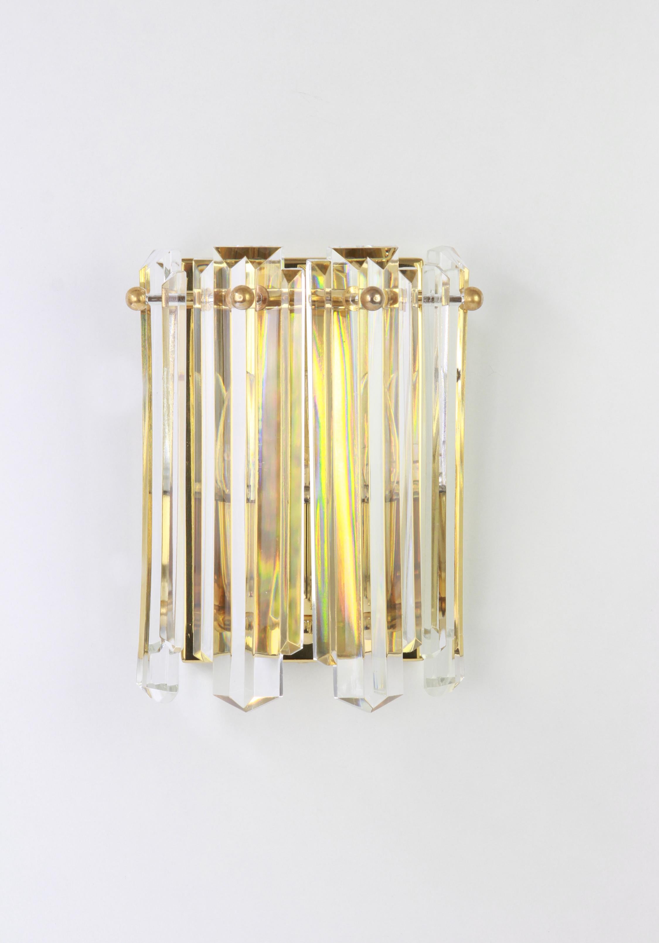 Maravilloso par de apliques de pared de latón dorado, fabricados por Kalmar, Austria, hacia 1970-1979.

Gran estructura que reúne 5 copas de cristal tallado, que refractan maravillosamente la luz.
Pequeños signos de envejecimiento.

Cada aplique