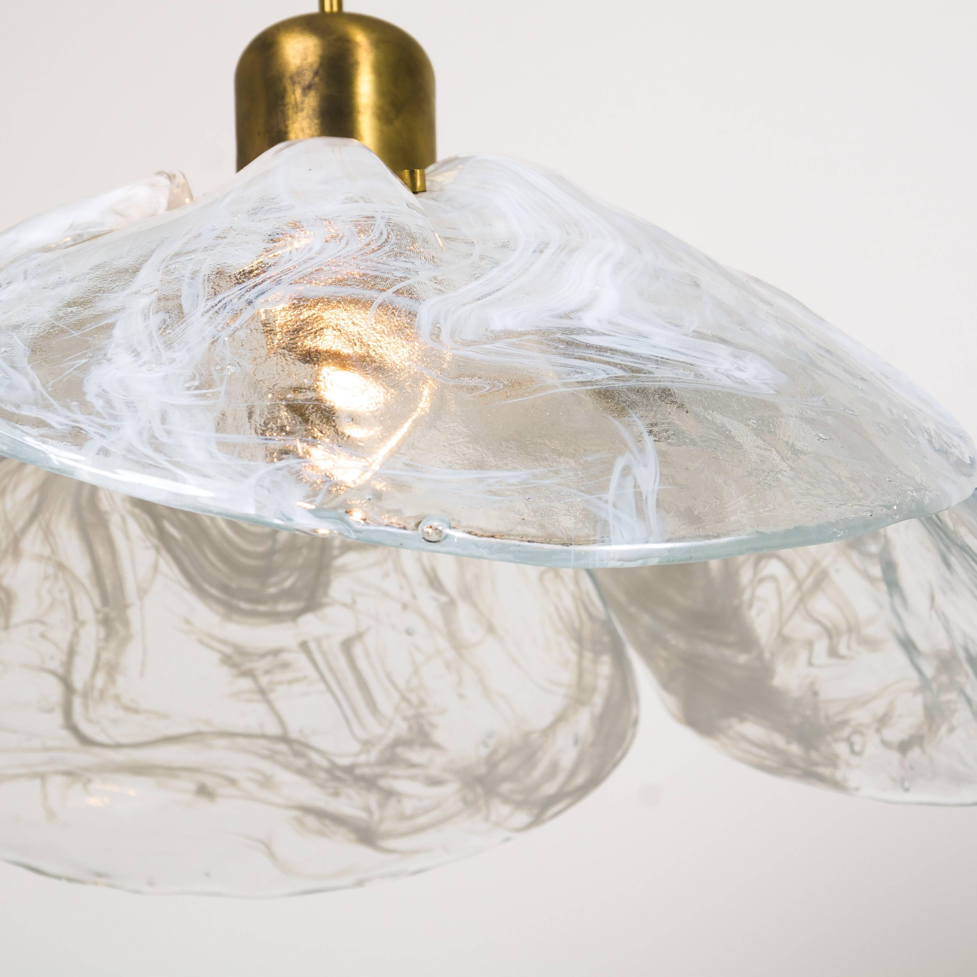 Two beautiful high quality midcentury brass chandeliers with four melting glass panels in the shape of a flower. Designed and executed by Kalmar Vienna in the 1970s. Made of hand blown melting clear and white glass.

Cleaned and well-wired, in