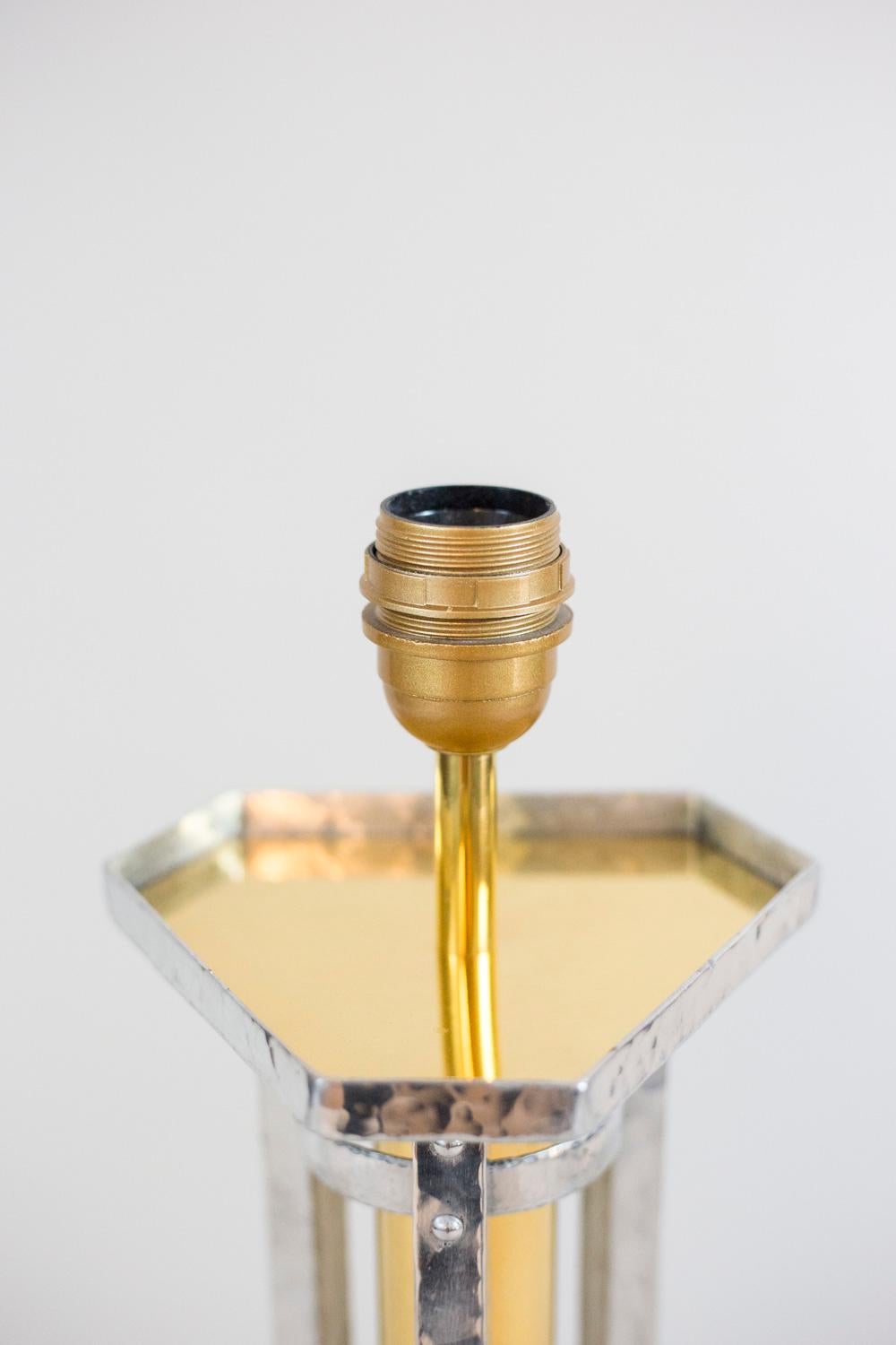 Coppia di grandi lampade in fusione di alluminio argentato martellato e bronzo dorato. Fusto di forma cilindrica in bronzo dorato circondato da tre bastoni argentati di forma quadrata, due anelli argentati nella parte superiore e un tubo con motivi
