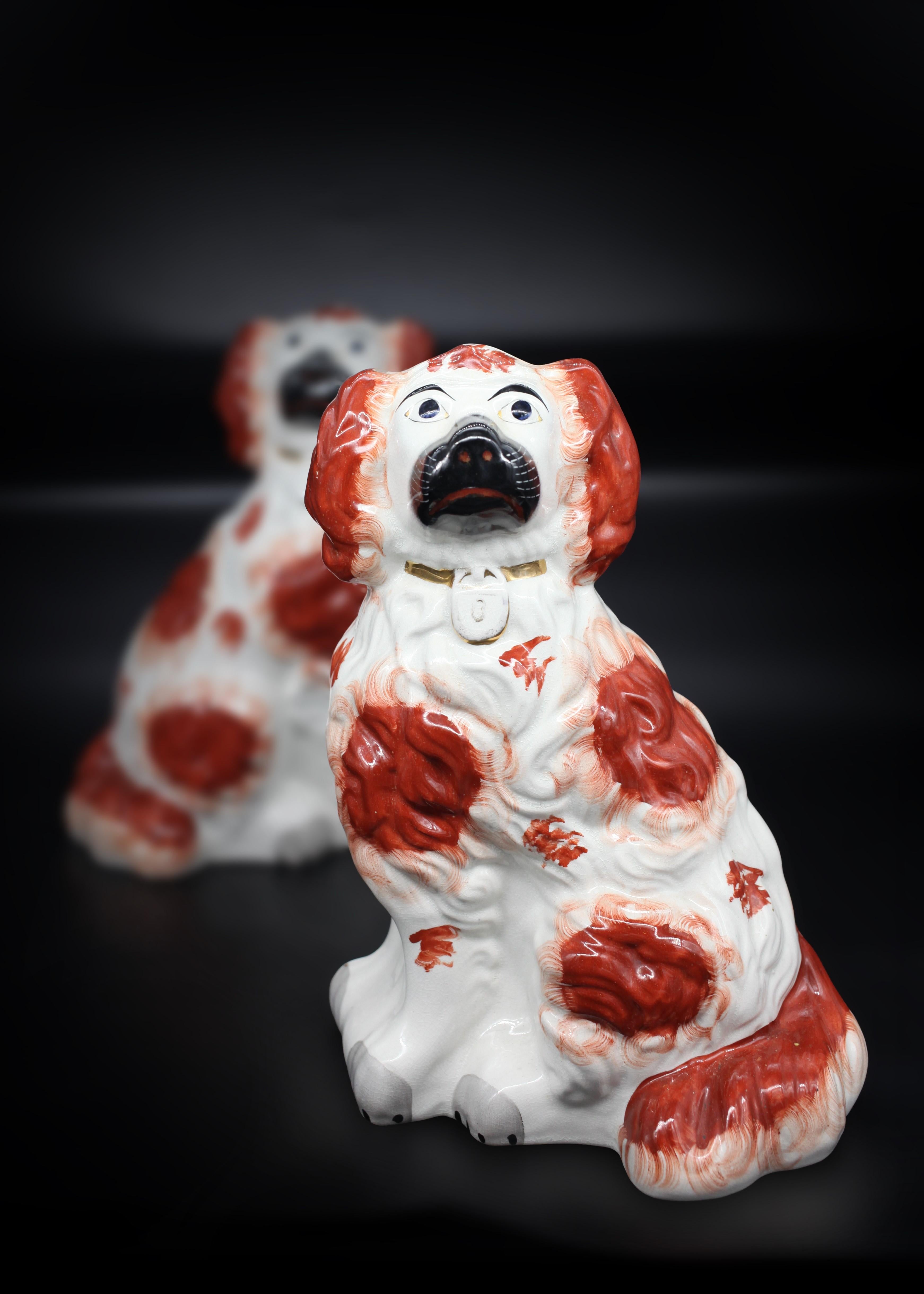 A large pair of English Staffordshire porcelain figures of orange and white seated spaniel dogs with gold collars. Their two front legs are separated, a more delicate, therefore rare process, making this pair one of the rarest models of dogs. This