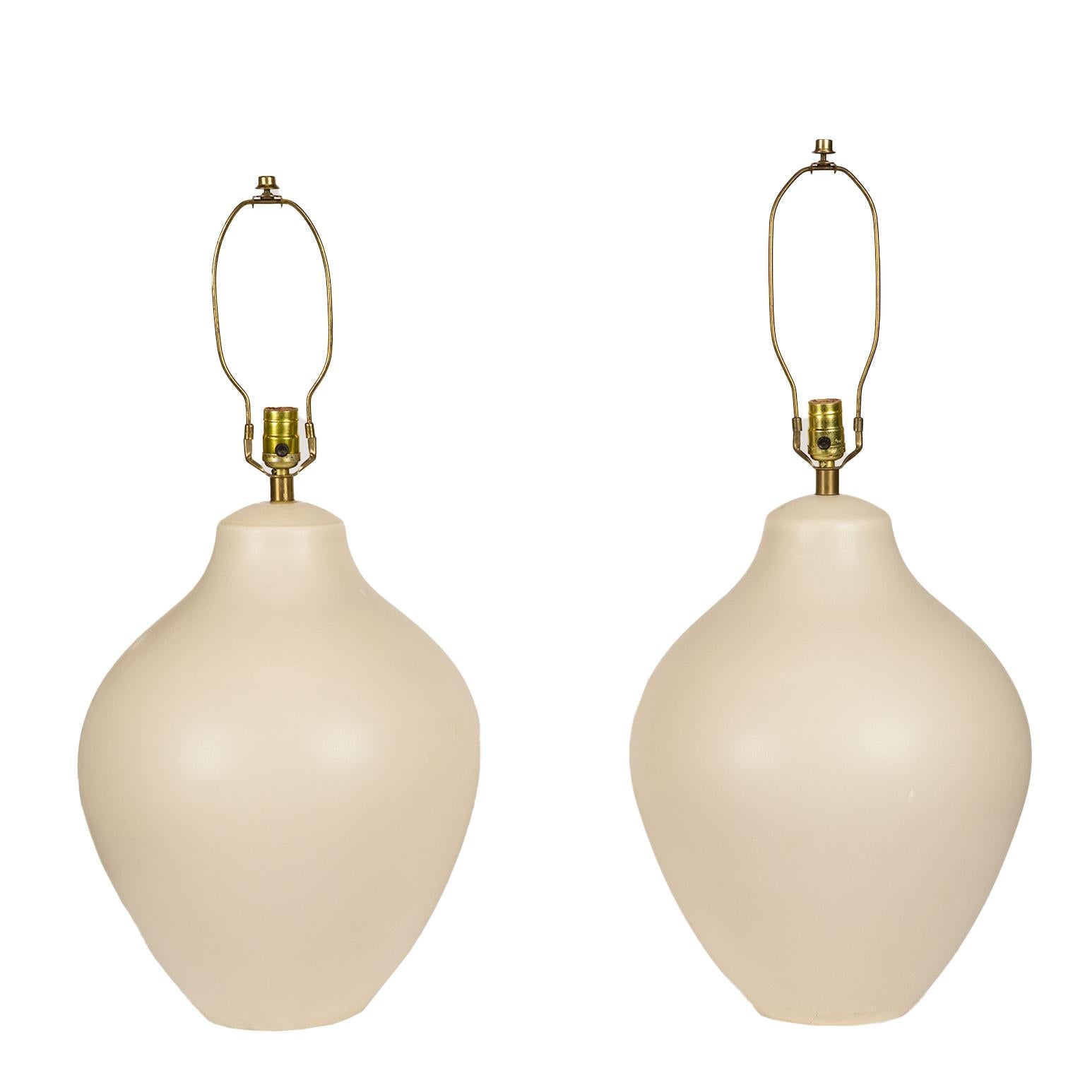 A stunning very large and rare pair of Mid-Century Modern table lamps by Lotte & Gunnar Bostlund in soft white glaze from the early 1960's. Featuring the original silk and fibreglass back, off-white shades.
The lamps are a matching pair as they are