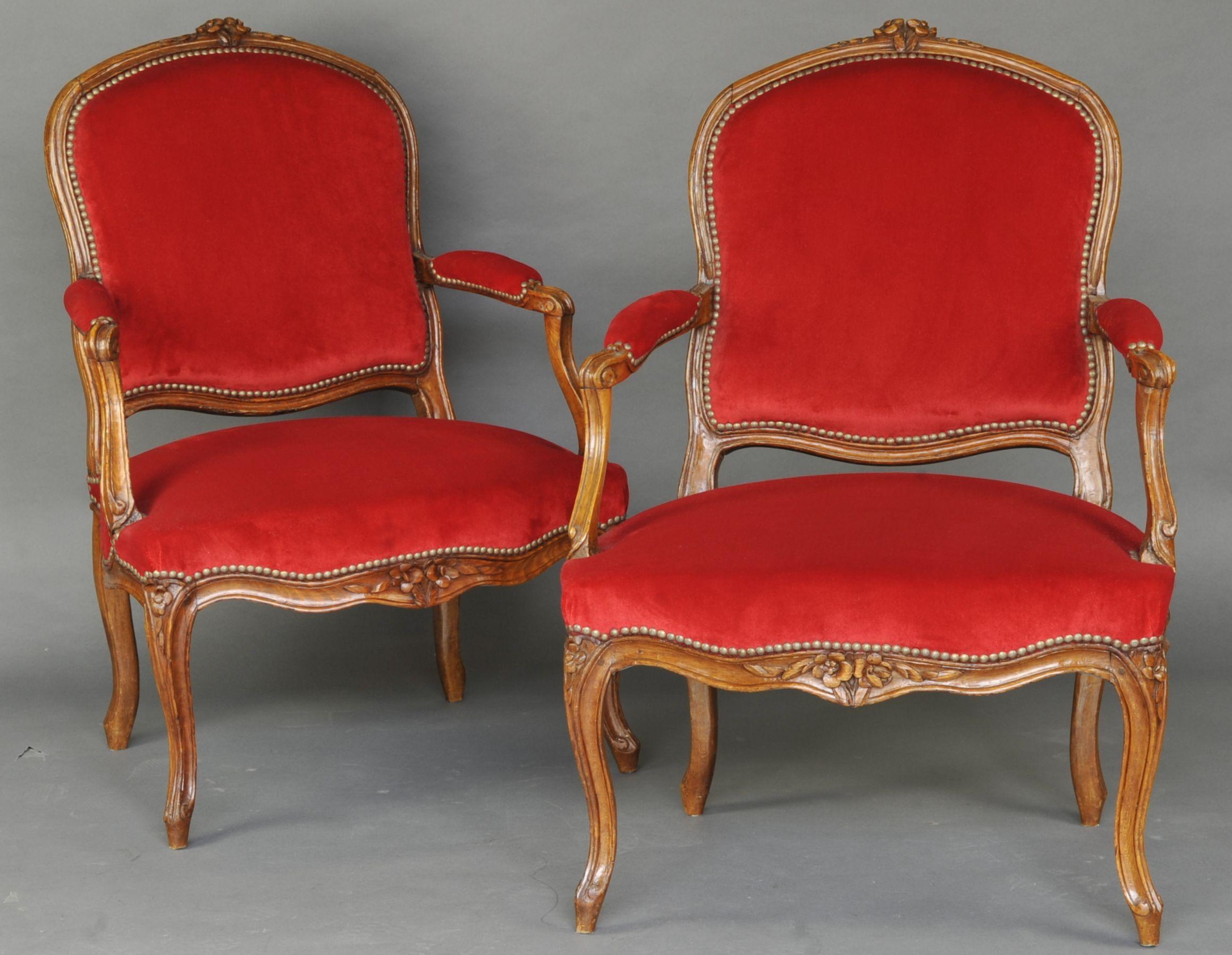 Magnifique paire de fauteuils Louis XV en hêtre sculpté, dossiers à la reine, consoles à accoudoirs en fouet, ceintures festonnées très élégantes sculptées de filets et de bouquets de fleurs.

Très beau tissu en velours rouge de Lelièvre à
