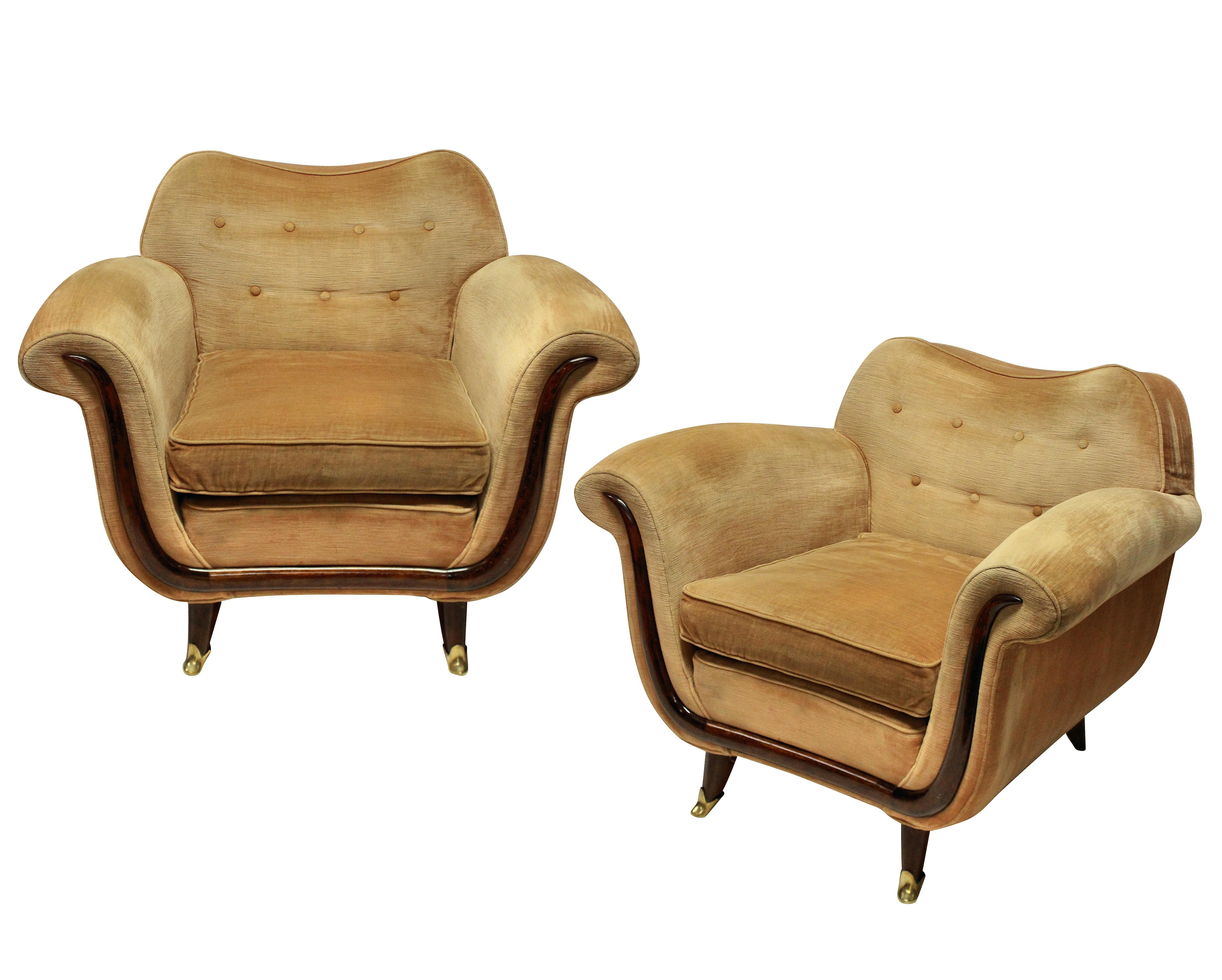 A pair of large and comfortable lounge chairs by Guglielmo Ulrich. With sculptural mahogany detailing and feet with brass sabot. In their original cleaned velvet, which is in good order, but can be upholstered to any specification.