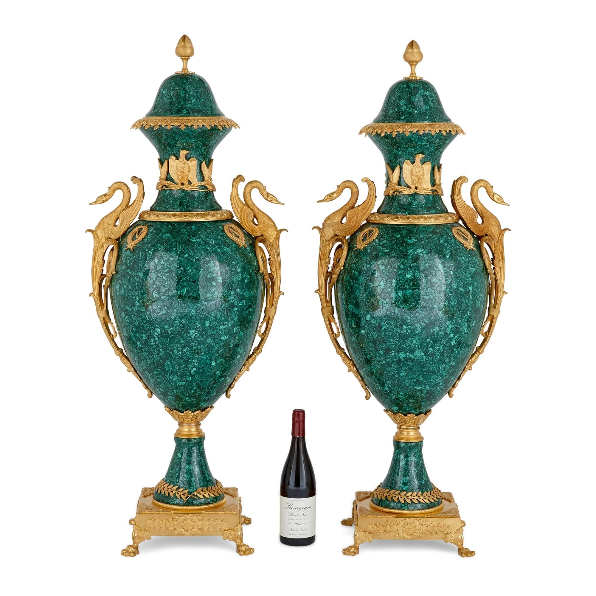 Diese prächtigen, in Malachit und Ormolu gefassten Vasen sind im französischen Empire-Stil ausgeführt und mit einem vergoldeten Dekor versehen, das unverkennbar von Selbstbewusstsein, Stolz und Sieg zeugt. Auf beiden Seiten zeigen sie wunderschön