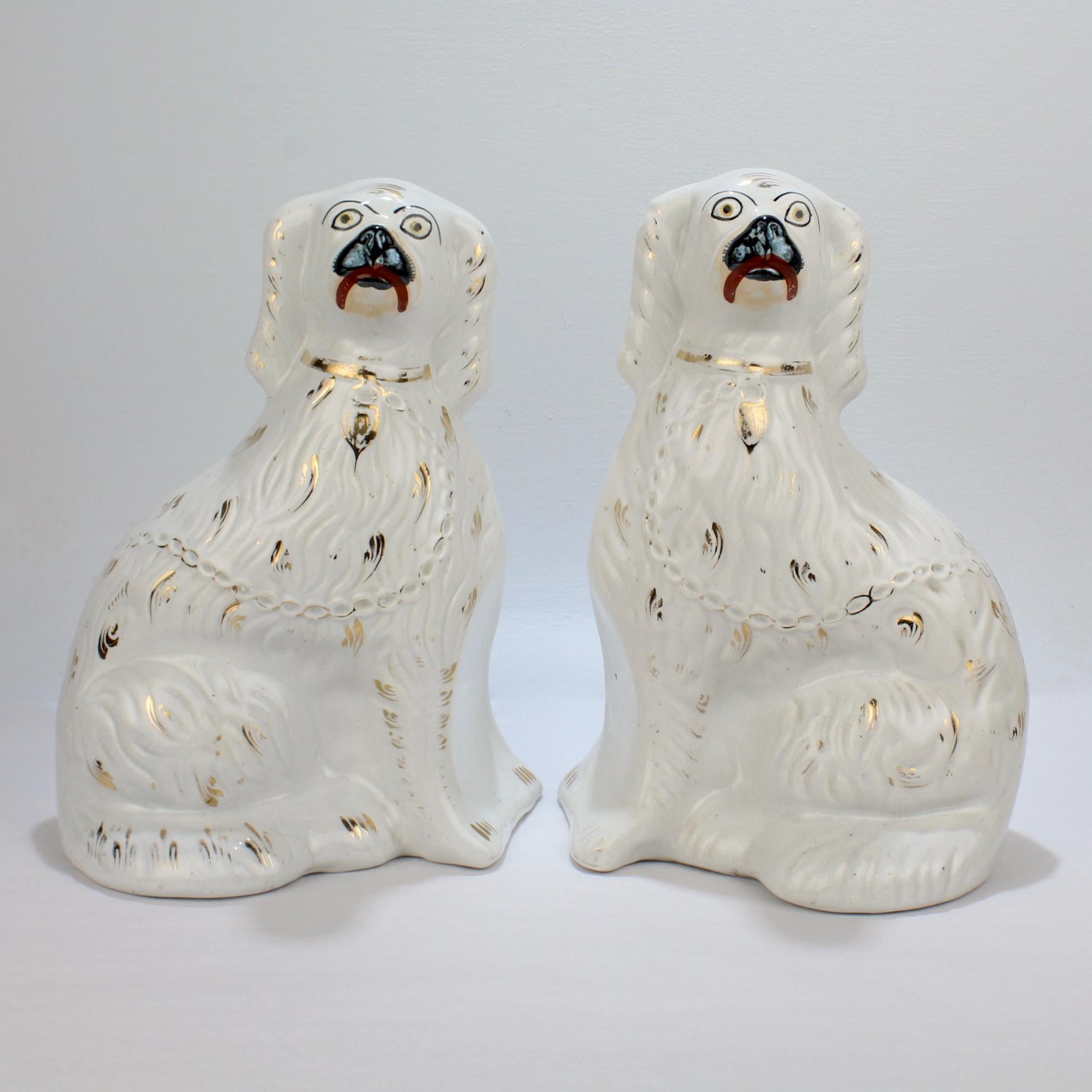 A fine pair of antique Staffordshire pottery spaniels. 

These wonderful dogs have raised faux chains and gilt collars, as well as gold spot decorations throughout. 

They are a matched, complementary pair. 

Height of taller dog: ca. 12 1/2