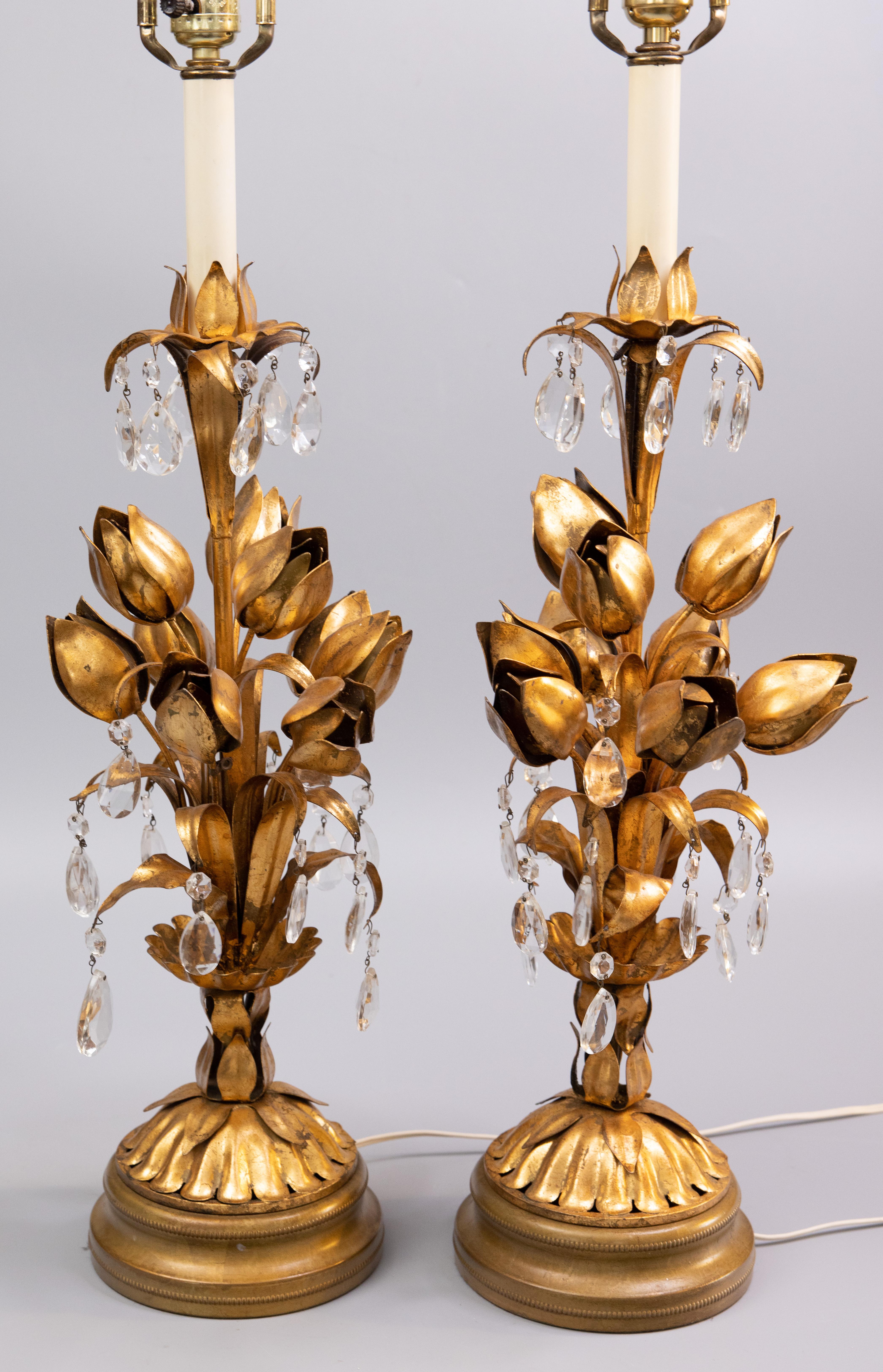 A fabulous pair of tall Mid-Century Italian Florentine gilt tole and crystals lamps. These gorgeous gilded lamps are a nice large size with a beautiful floral design, scrolling leaves, teardrop crystals, and lovely original surface and patina. They