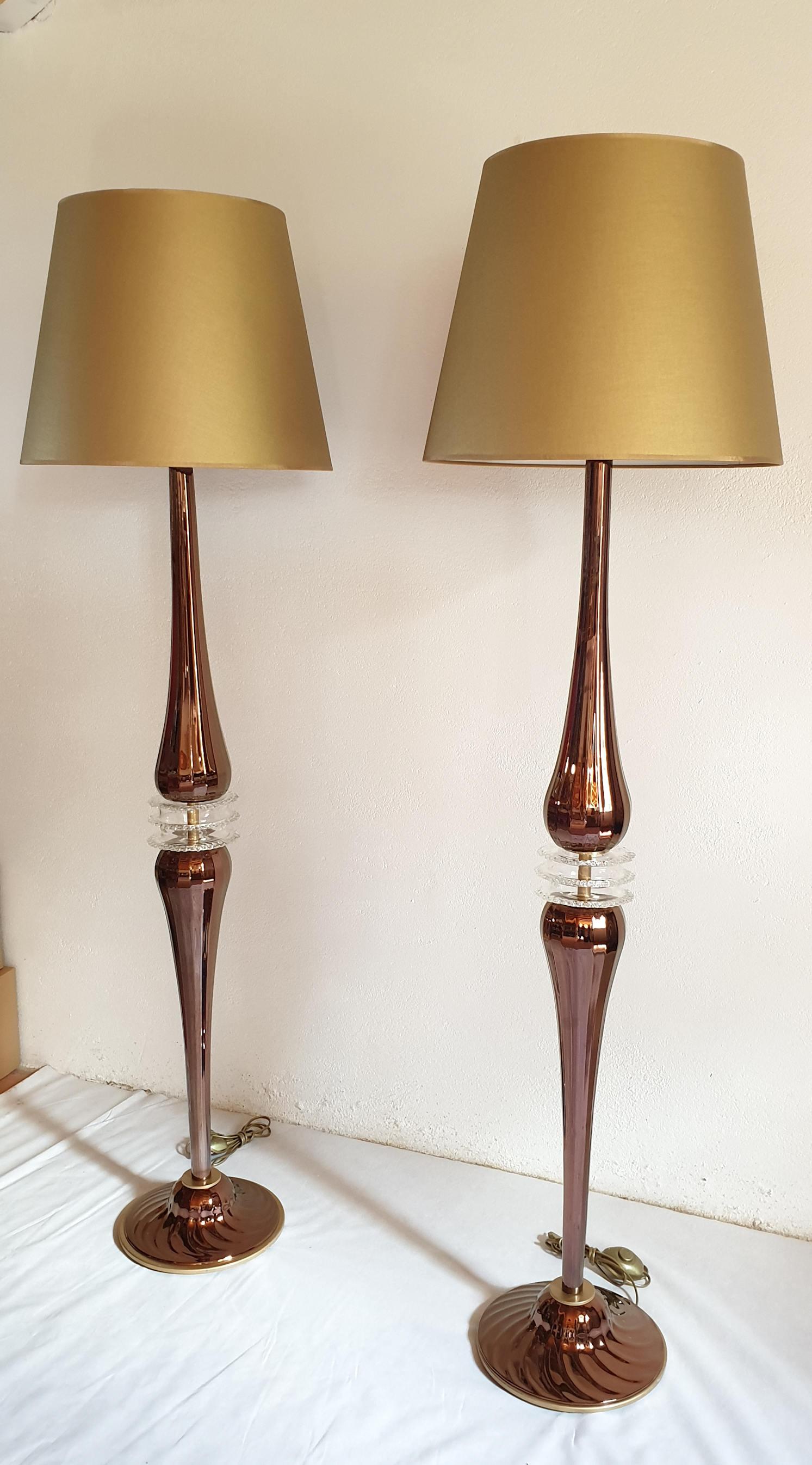 Large pair of Mid-Century Modern hand blown Murano glass floor lamps, with beige and gold fabric new shades.
In the style of Cenedese, Italy.
The glass is in copper mirrored color, with regular lines, and clear glass centre sfere.
They are hand