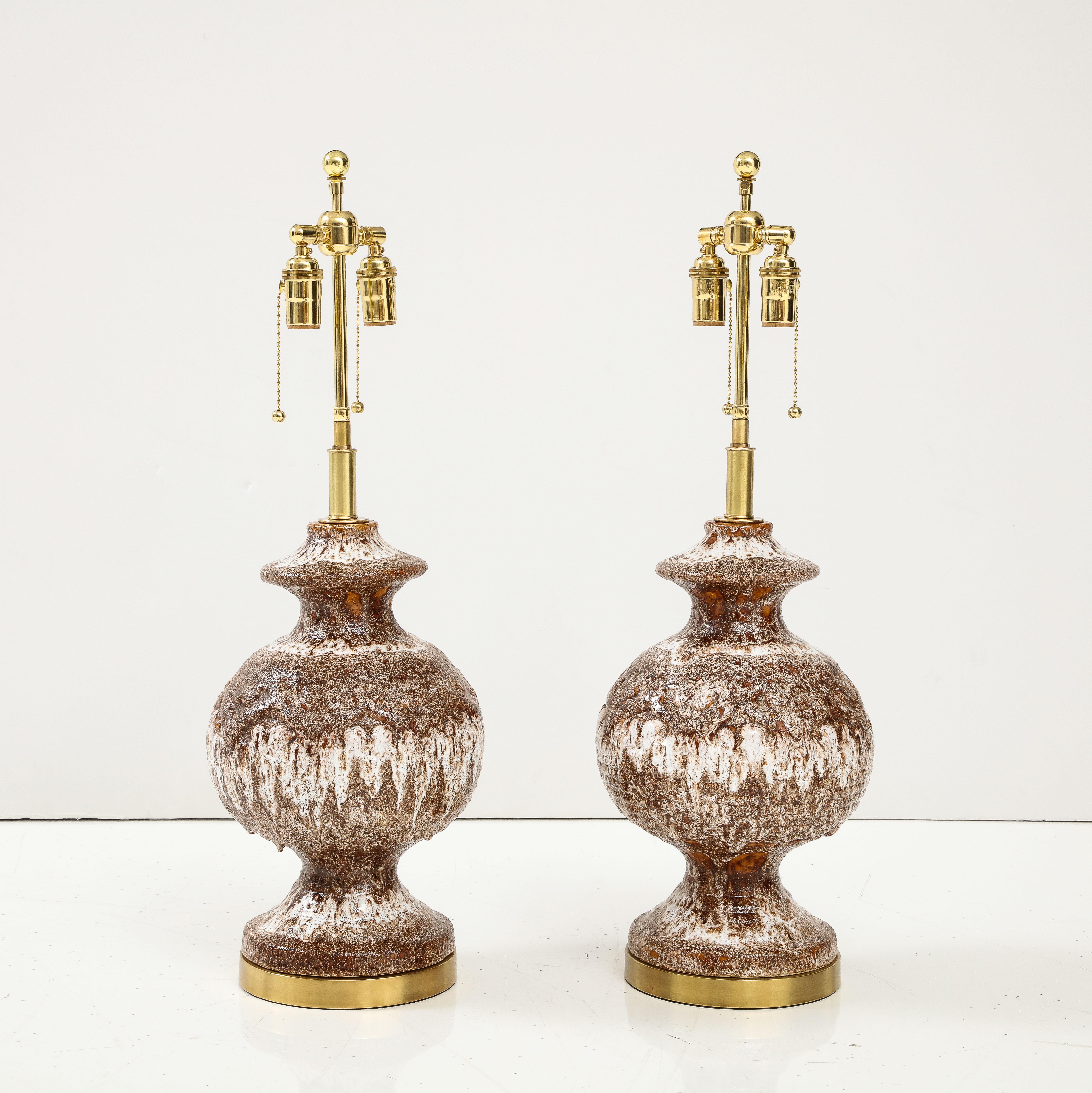 Pair of Large West German ceramic lamps with a wonderful textured lava glaze.
The lamps sit on Brass bases and they have been Newly rewired with adjustable polished brass double clusters that take standard size light bulbs and silk rayon cords.
Each