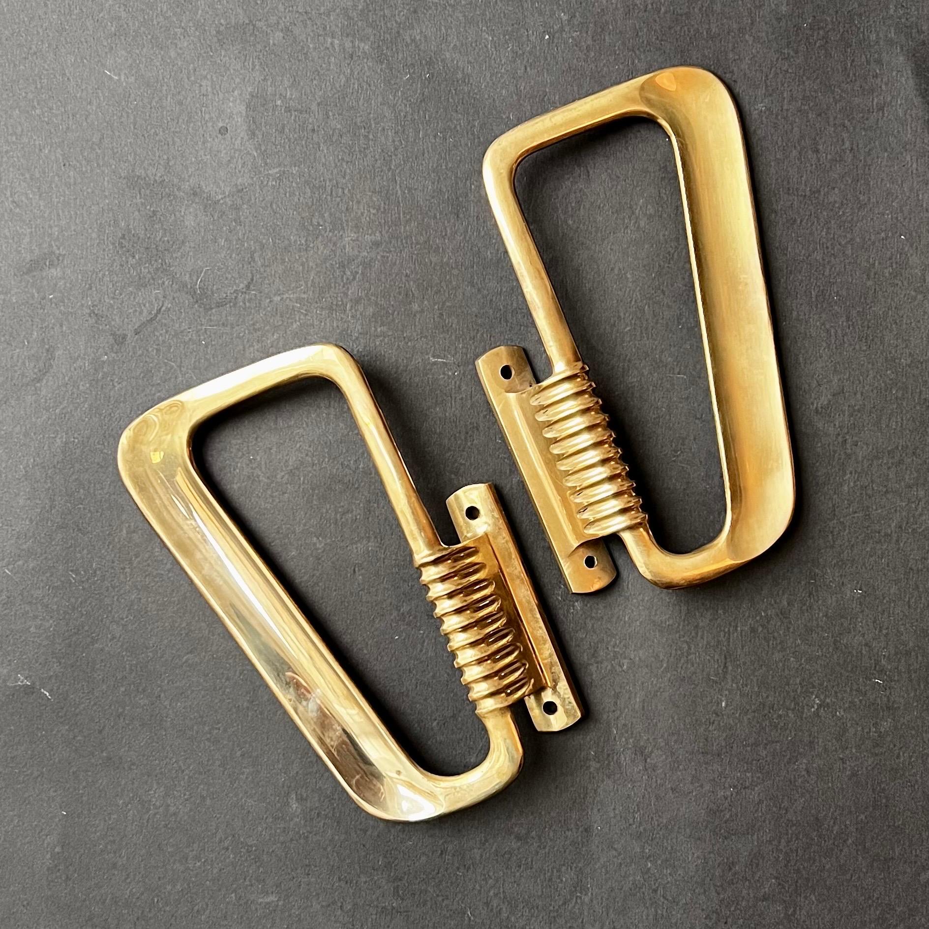 A pair of large Italian midcentury door handles of cast brass, with gentle contouring to suit their function. The pieces can be used separately or together; on double doors or opposite sides of a single door.

The handles are in good vintage