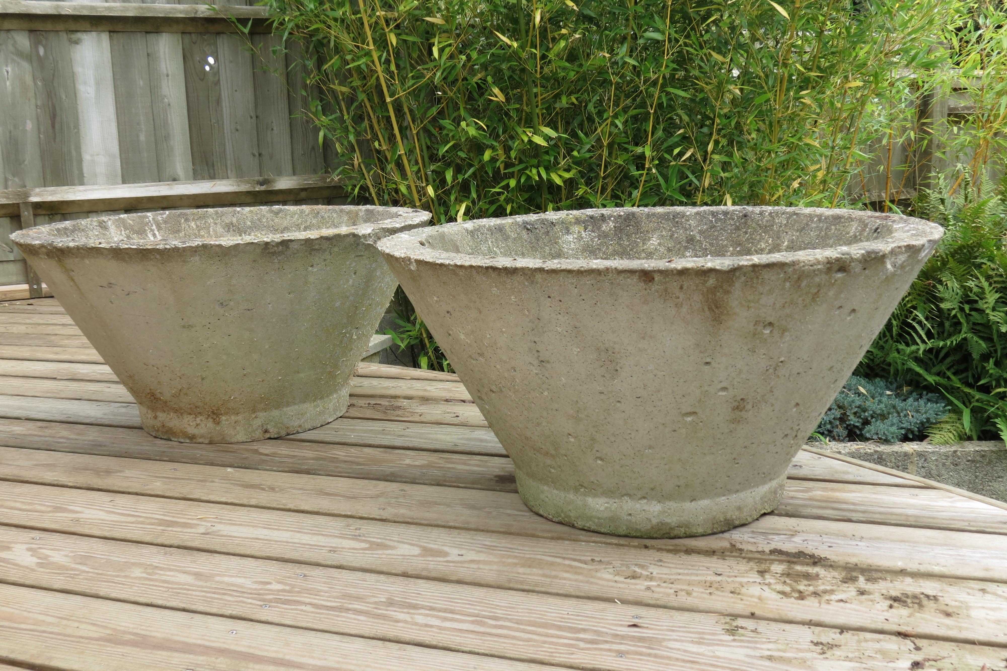 Wonderful pair of large solid concrete plant pots.  They date from the 1970s and would possibly have been used in a municipal setting.  Great modernist shape would provide excellent potting for any garden.

In good over all condition, structurally