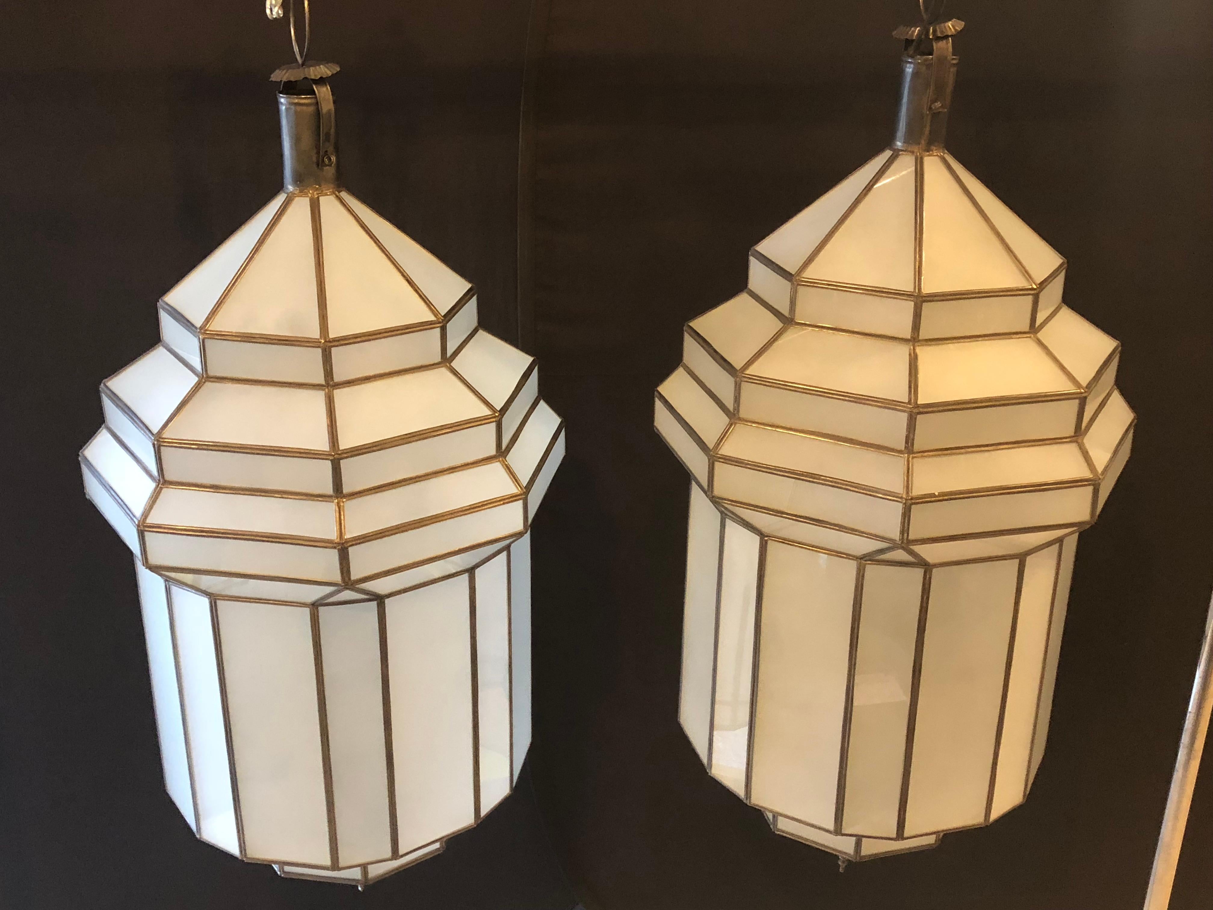 A gorgeous handcrafted, having individual panes, pair of large Moroccan Moorish hanging lanterns or ceiling fixtures featuring sandblasted frosted milky glass and patinated metal frames. The octagonal shaped large pendants have a small door on the