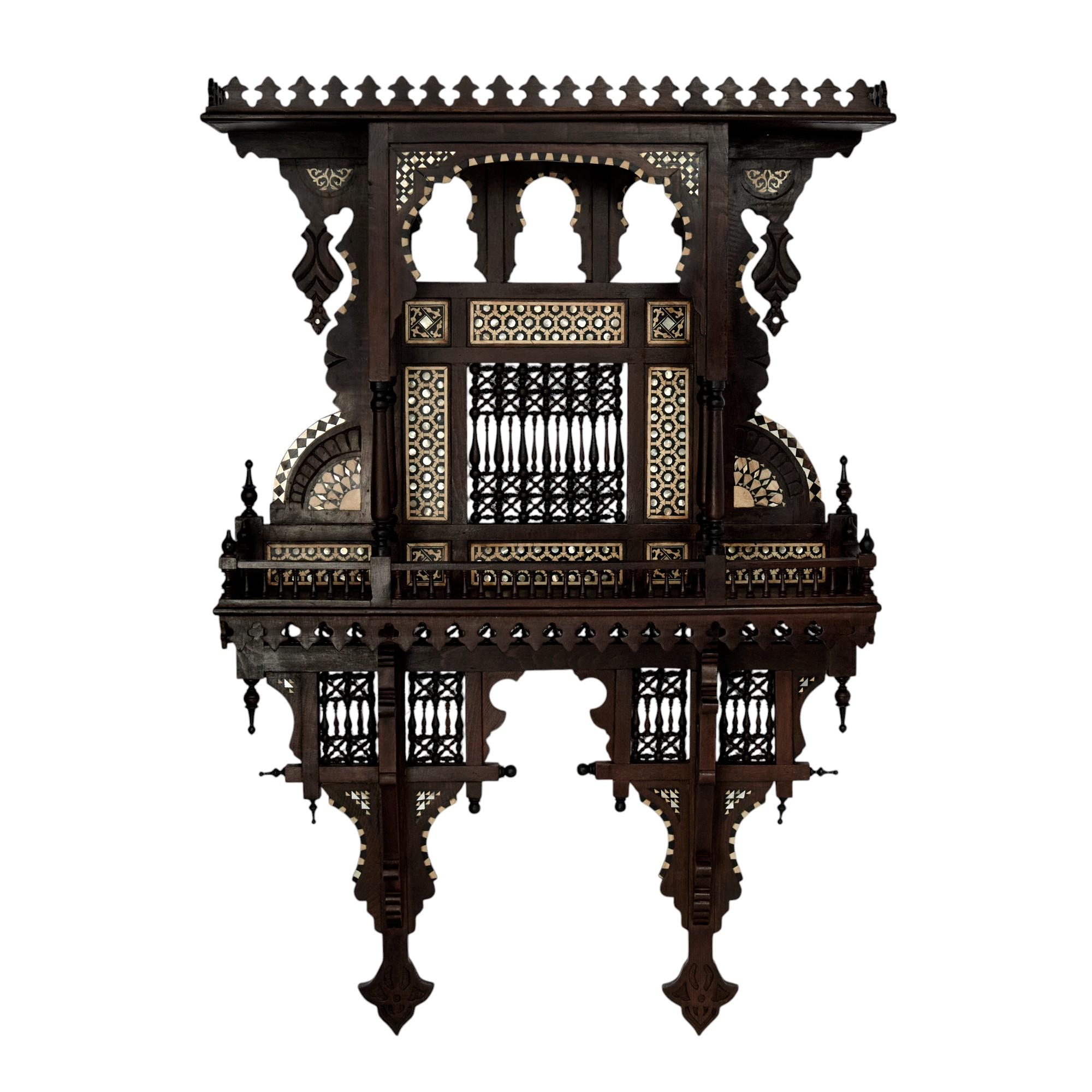 Rare and remarkable Moroccan wall shelves handcrafted in mahogany featuring parapet tops, architectural nooks, finials, balustrades, stick and ball panels, elaborate geometric inlays of mother of pearl and bone all in classic Moorish form.