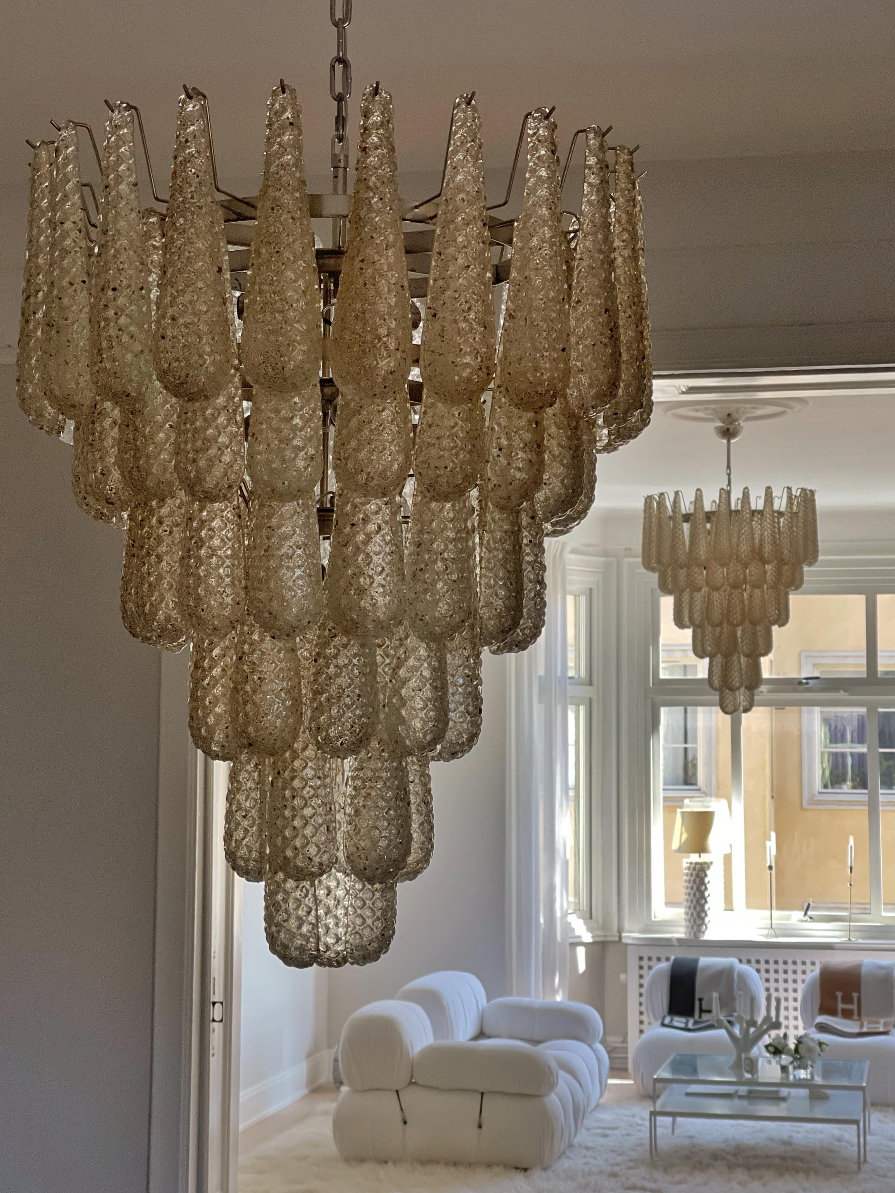 Coppia di enormi lampadari di Murano con prismi in vetro formato a goccia di colore miele/ambra. u2028Lampadario contemporaneo in stile tradizionale italiano di metà secolo.
I lampadari sono composti da 75 prismi di cristallo delle dimensioni di 29