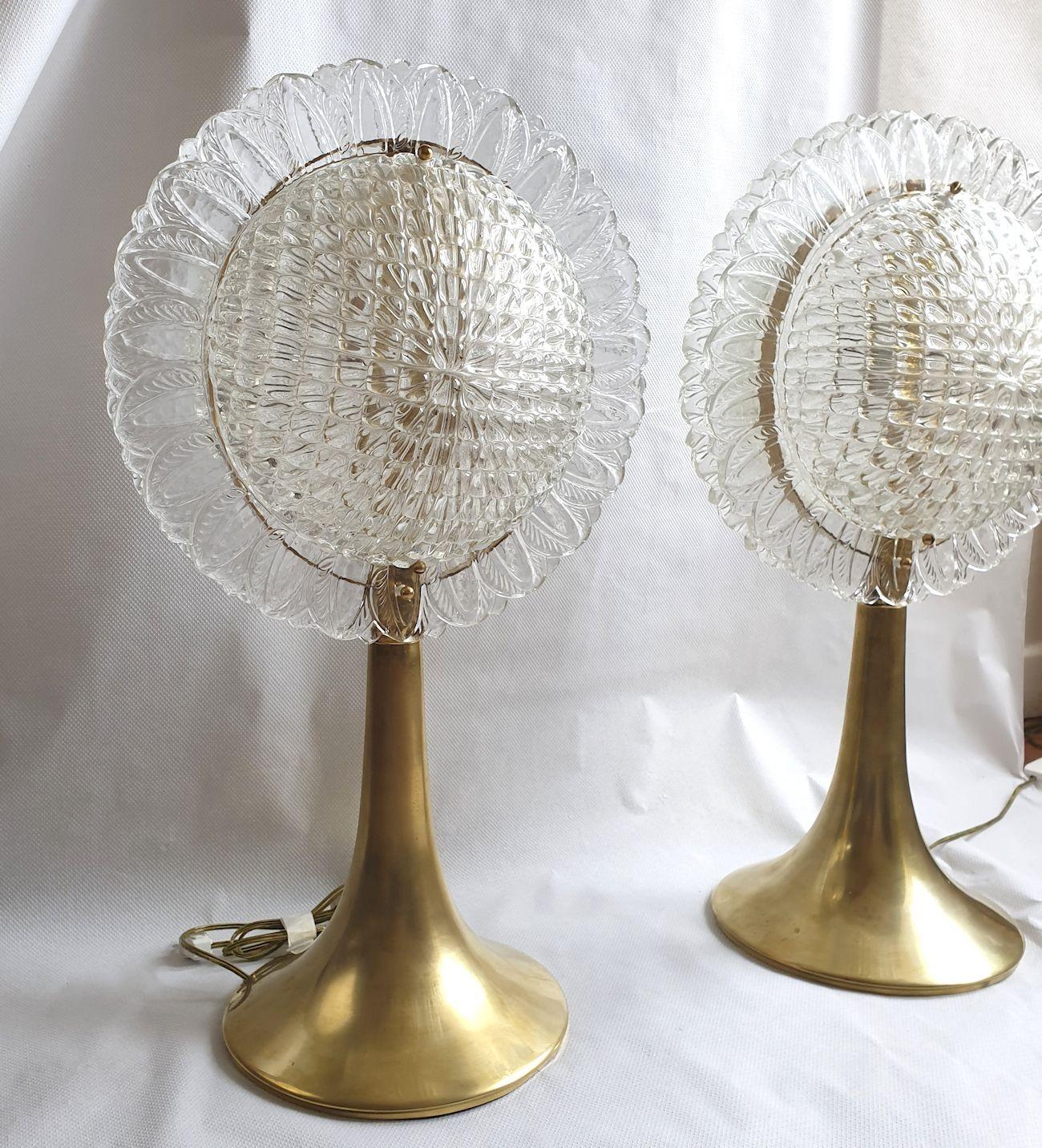 Pair of large Mid-Century Modern table lamps, attributed to Mazzega, Italy 1960s.
The vintage lamps are made of brass mounts and a Murano glass clear and translucent shade.
The lamps have one polished brass central leg, with a modern tulip