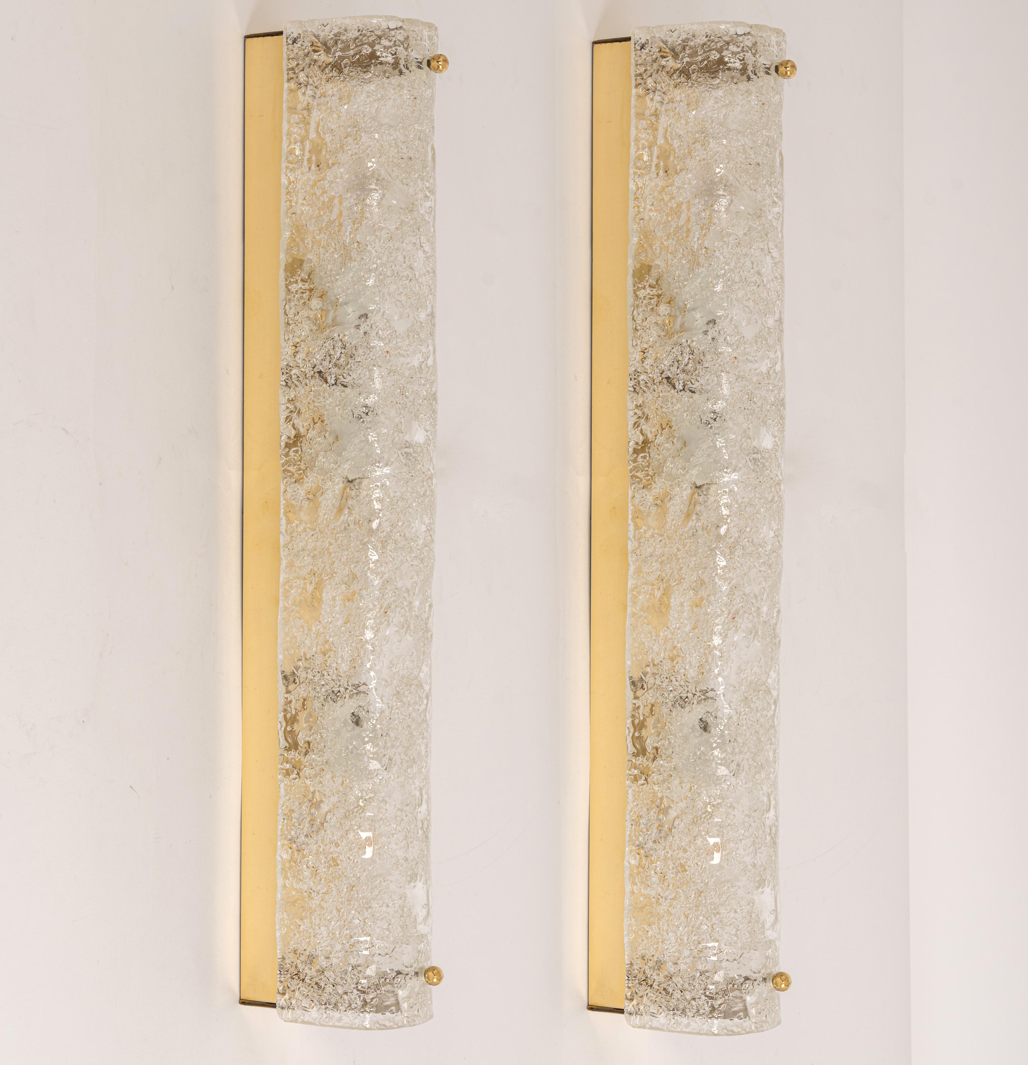 Pair of large handcrafted Murano glass on a brass base sconces by Hillebrand, Germany, circa 1960s.

It consists of textured quality clear crystal tubular shade simulating ice on a Brass frame.
The design allows this light to be placed either