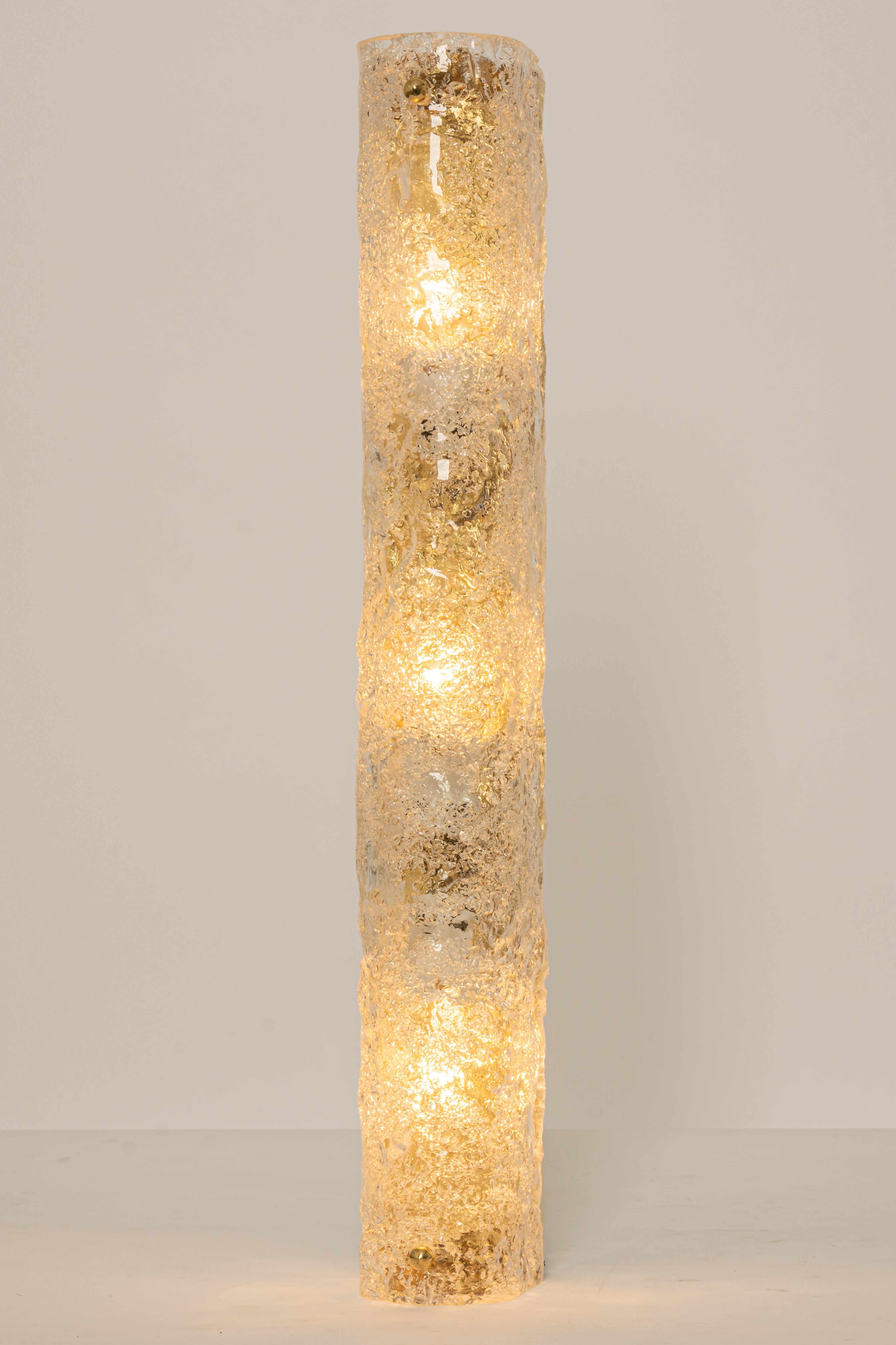 Pareja de grandes apliques artesanales de cristal de Murano sobre base de latón, de Hillebrand, Alemania, hacia la década de 1960.

Consta de una pantalla tubular de cristal transparente de calidad texturizada que simula hielo sobre un marco de