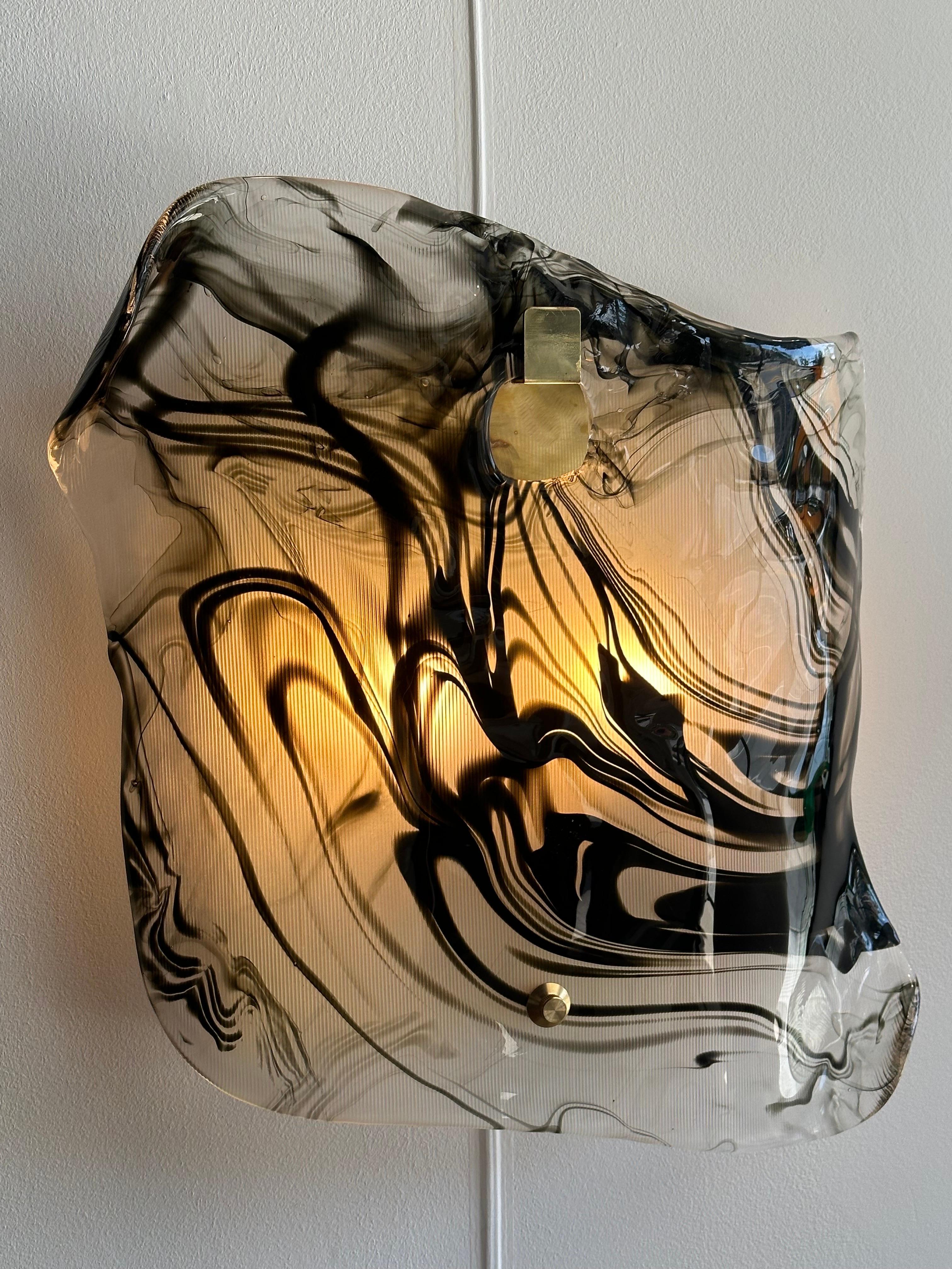 This outstanding pair of heavy glass sconces in a wavy and fluid design, opaque and wavy black inclusions. Hanging from a brass plate with TWO candelabra style sockets. VERY whimsical and sculptural. Large in scale - extremely unique. TWO pairs are