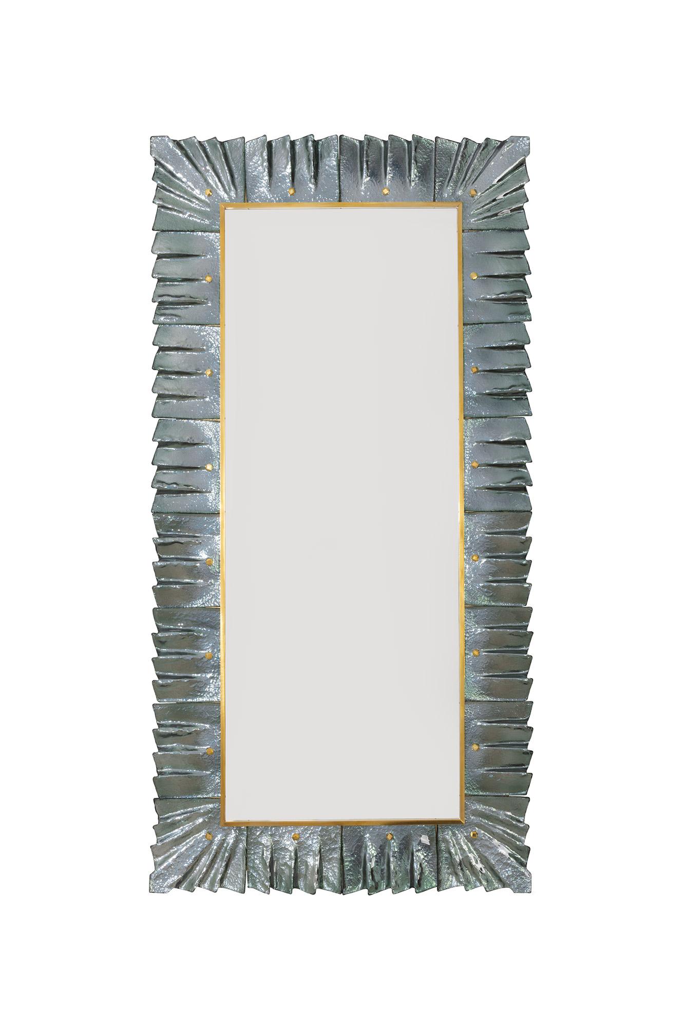 Pair of large rectangular Murano sea green teal glass and brass framed mirrors, in stock. 
Rectangular mirror plate surrounded with undulating glass tiles in sea green teal glass color held by brass cabochons. 
Luxury handcrafted by a team of